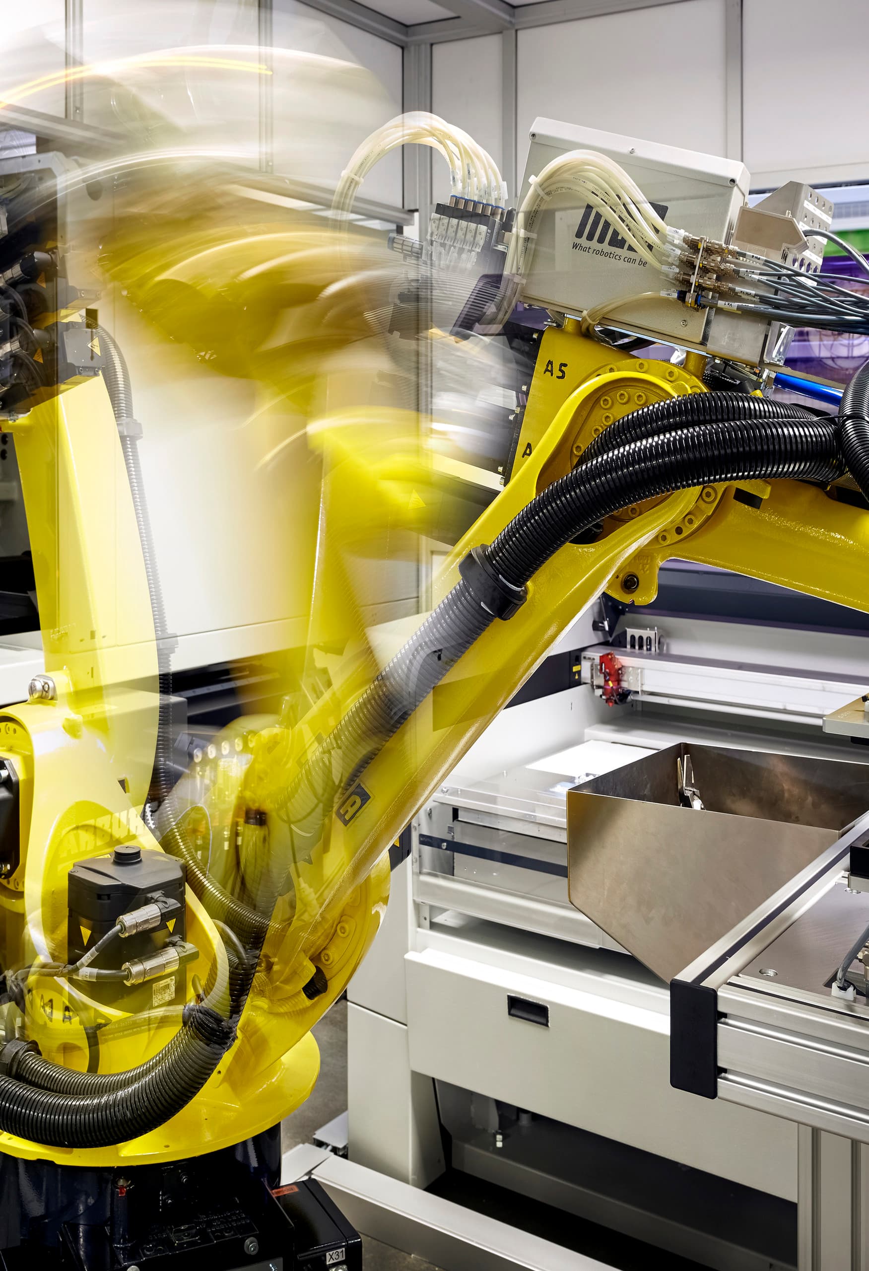 Automatisierte Fertigungszelle mit Industrieroboter für ERCO LED-Linsenproduktion.