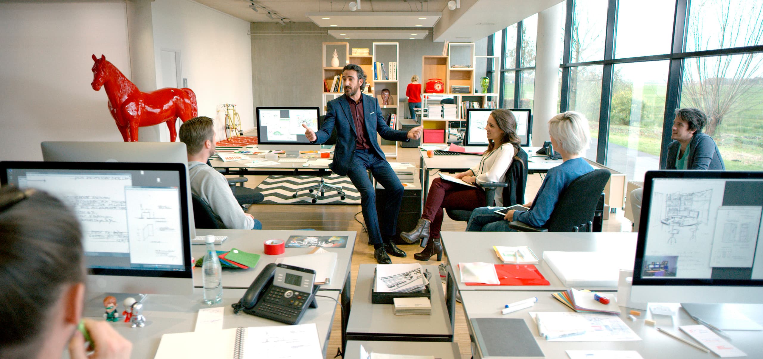 Besprechung in einem modernen Büro mit flexibler Bürobeleuchtung durch ein ERCO Schienensystem.