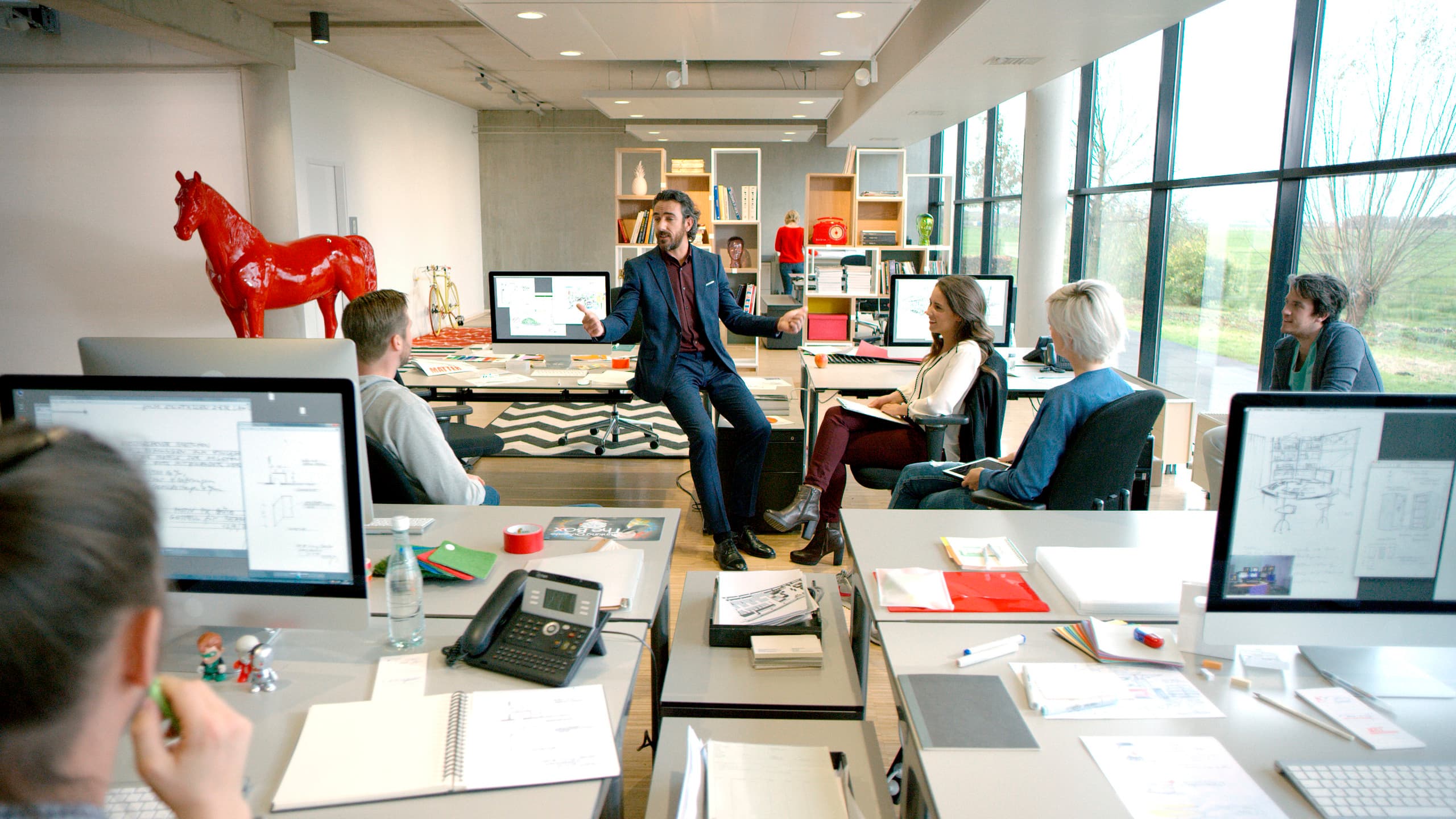 Besprechung in einem modernen Büro mit flexibler Bürobeleuchtung durch ein ERCO Schienensystem.
