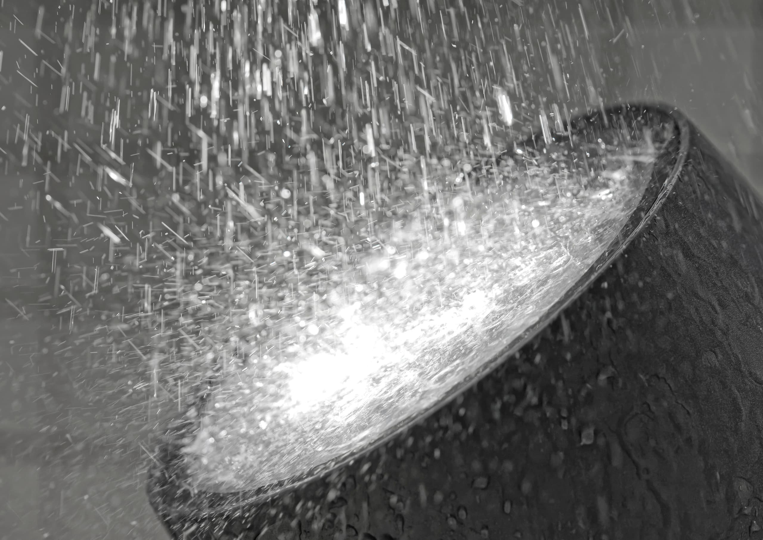 ERCO Fassadenleuchte im Regen, die Gebäude effektvoll in Szene setzt.
