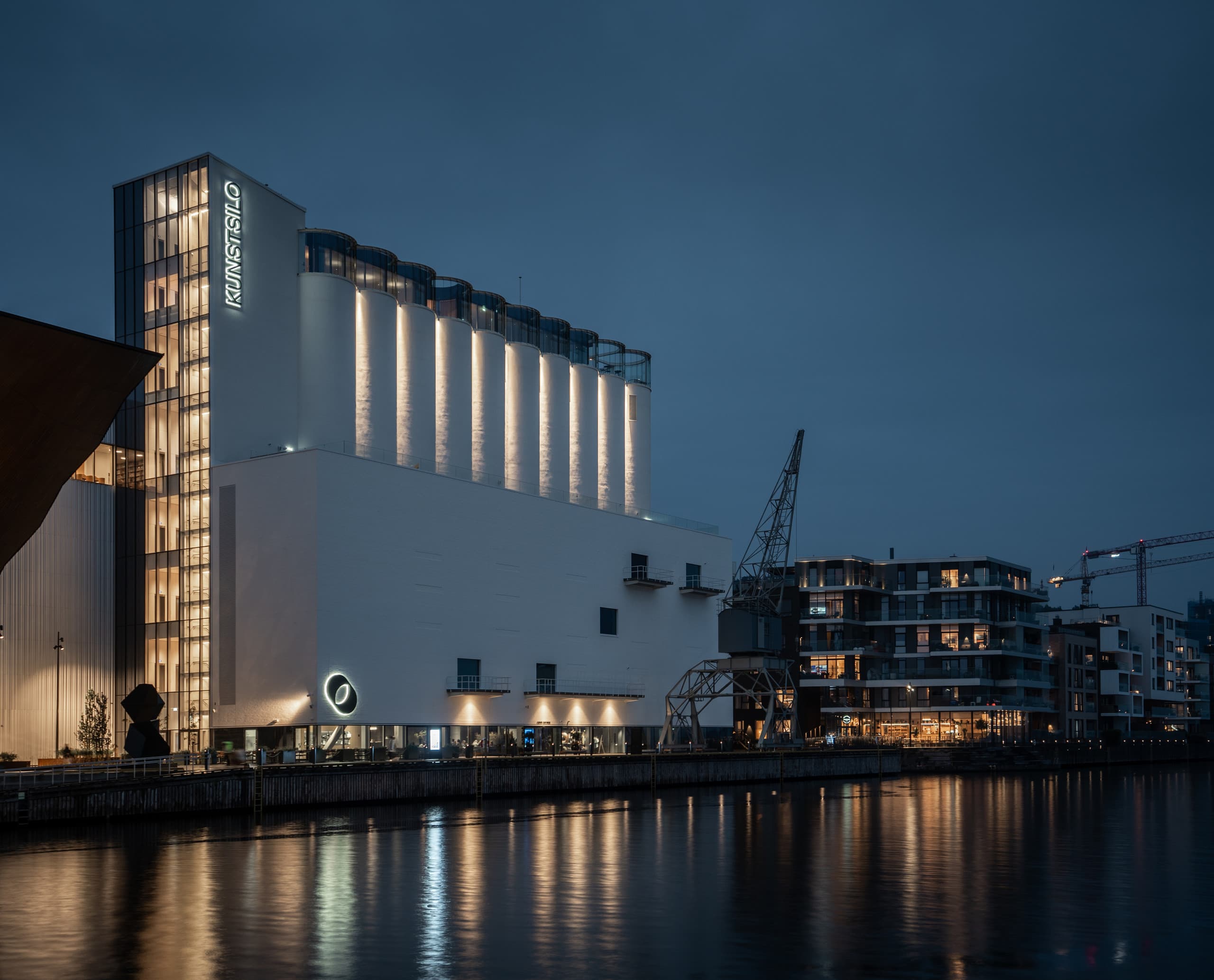 Kunstsilo Kristiansand: Beleuchtetes Kunstmuseum in einem ehemaligen Getreidespeicher am Wasser.