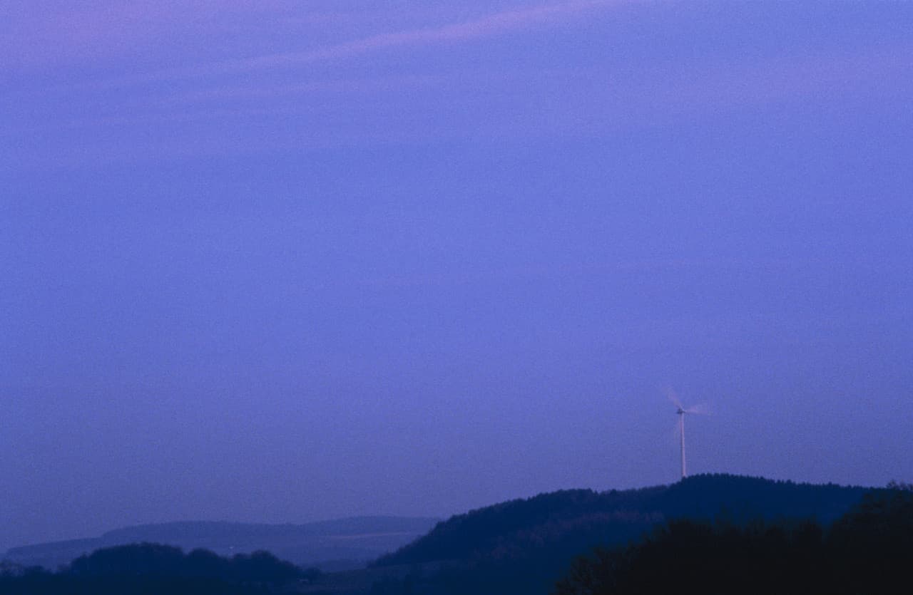 Windrad auf einem Hügel bei Nacht, demonstriert skotopisches Sehen.