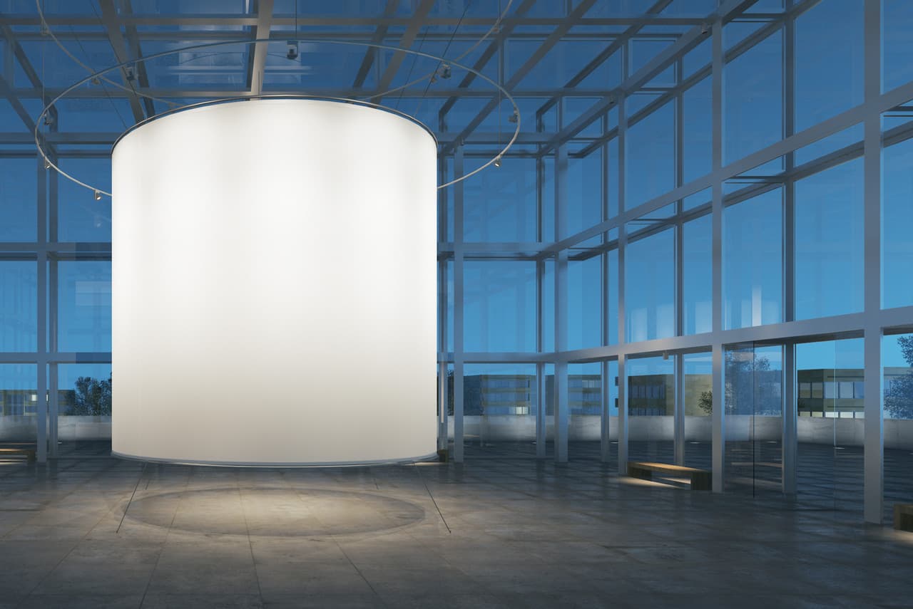 Runder, beleuchteter Zylinder in einem modernen Raum, der Form durch Licht betont.