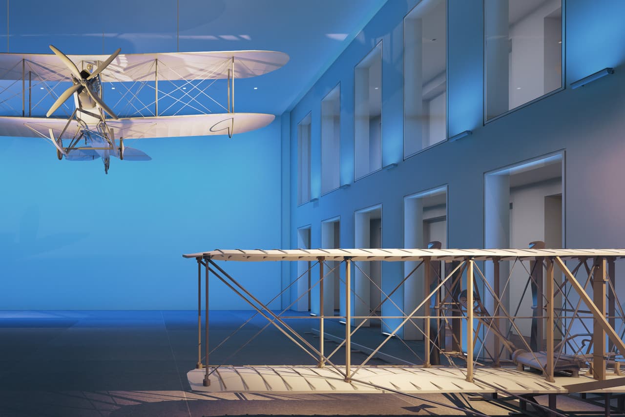 Flugzeugmodelle in einem Museum, beleuchtet mit farbigem Licht zur Akzentuierung der Ausstellungsstücke.