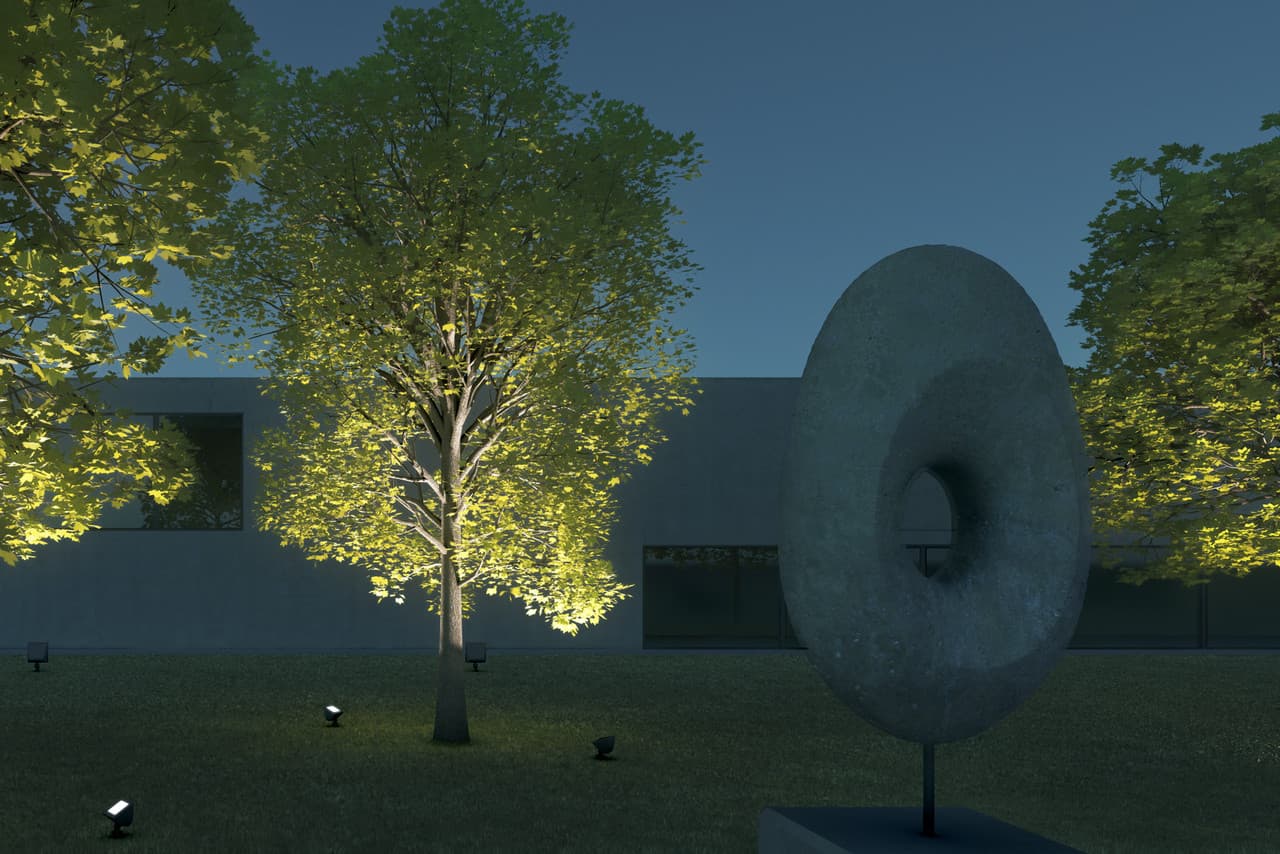 ERCO Lichttechnik: Akzentuierte Skulptur und Bäume durch Projektoren und Flutlichter im Garten.