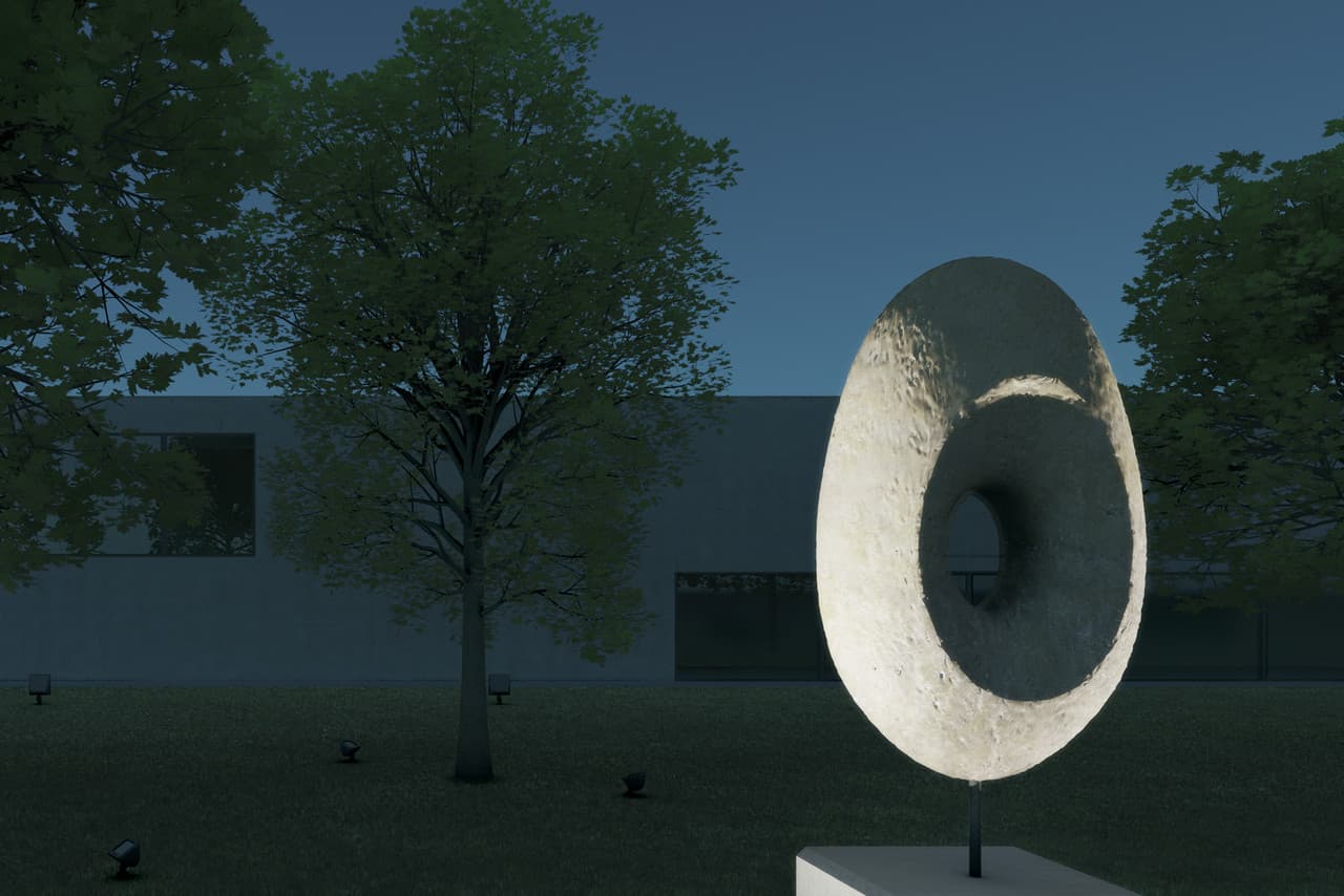 Beleuchtete Skulptur im Vordergrund, Bäume und Fassade im Hintergrund. ERCO Lichtgestaltung.