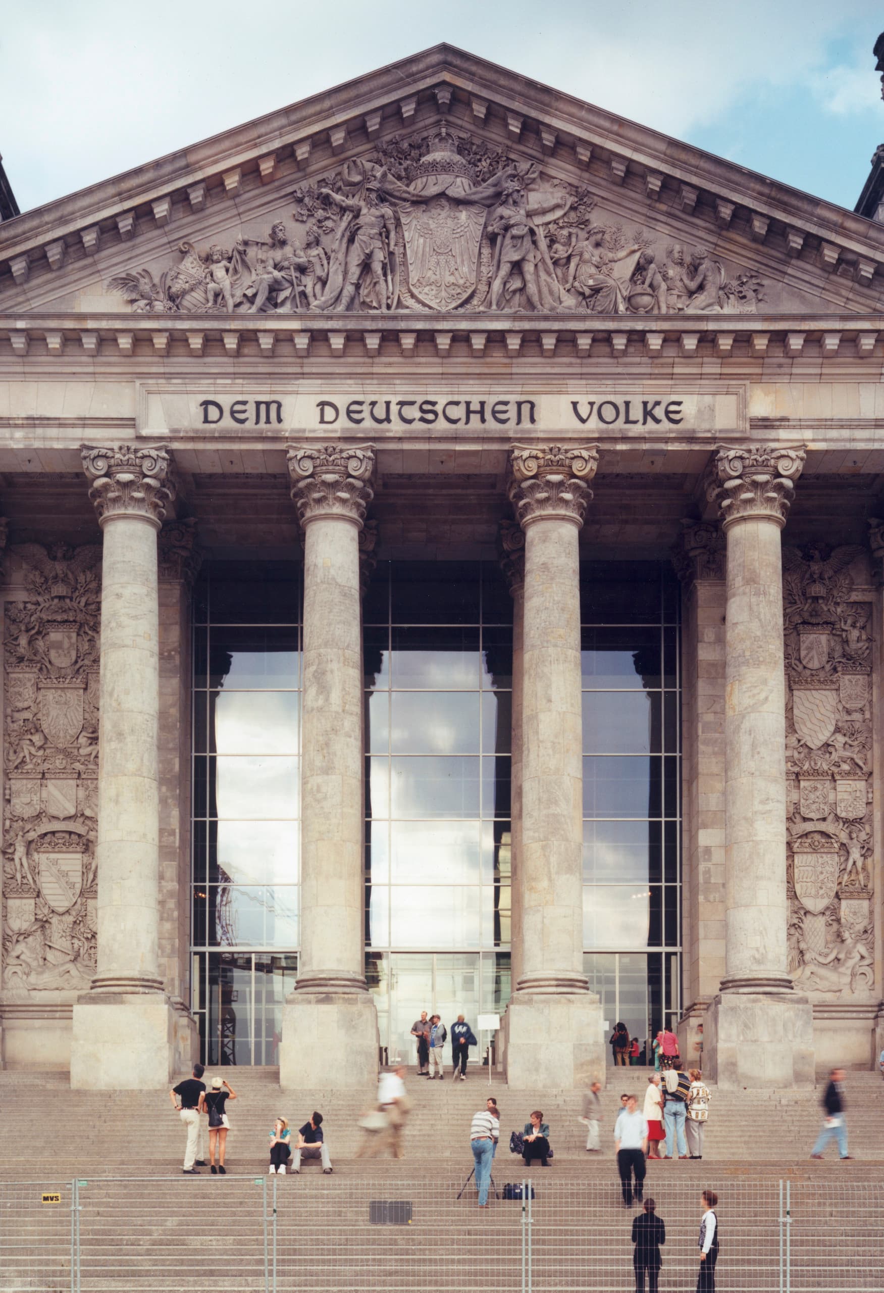 Der Reichstag in Berlin, Sitz des Deutschen Bundestages, mit Besucher auf der Treppe.
