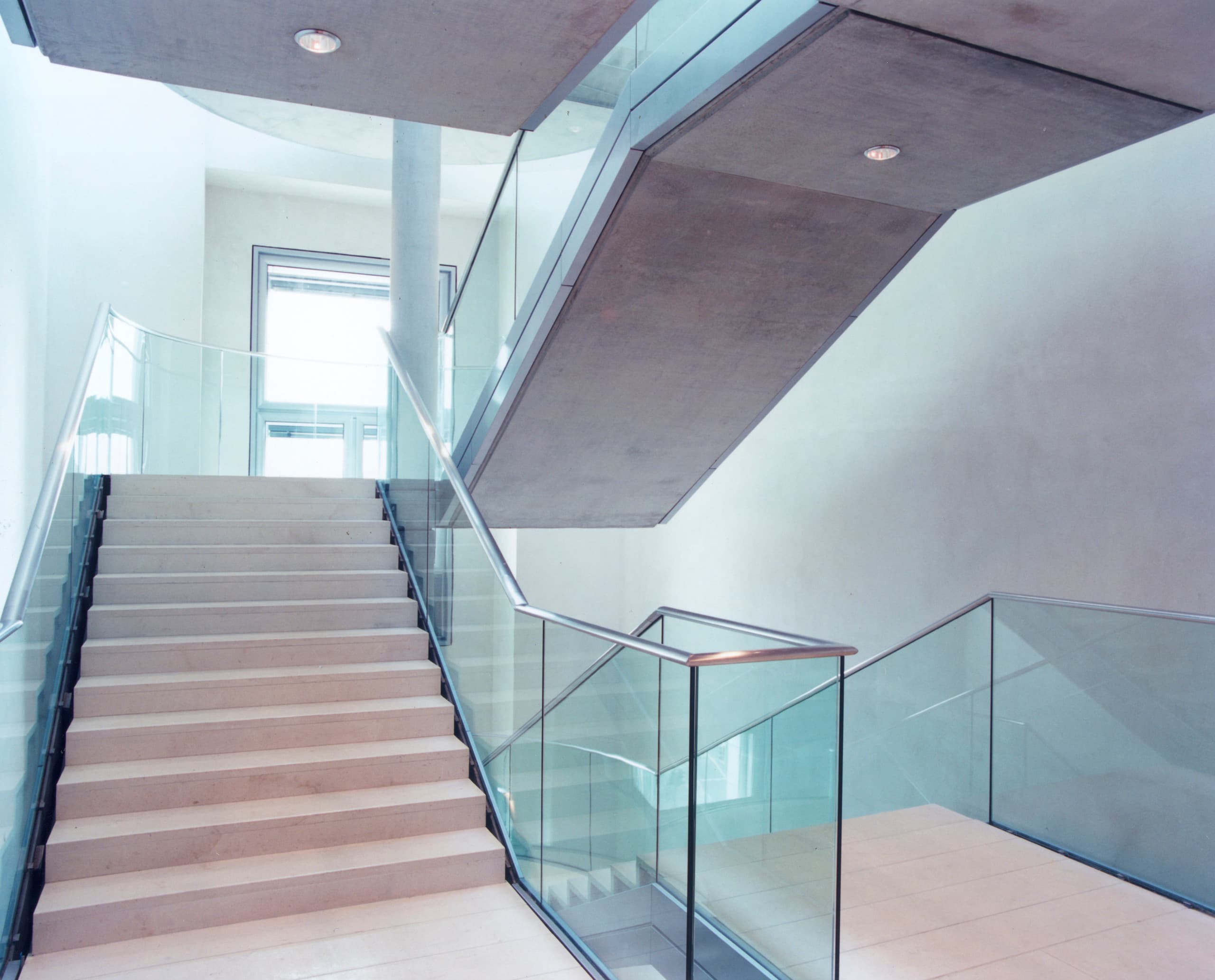 Treppenhaus im Reichstagsgebäude mit Glasgeländer und ERCO Beleuchtung.