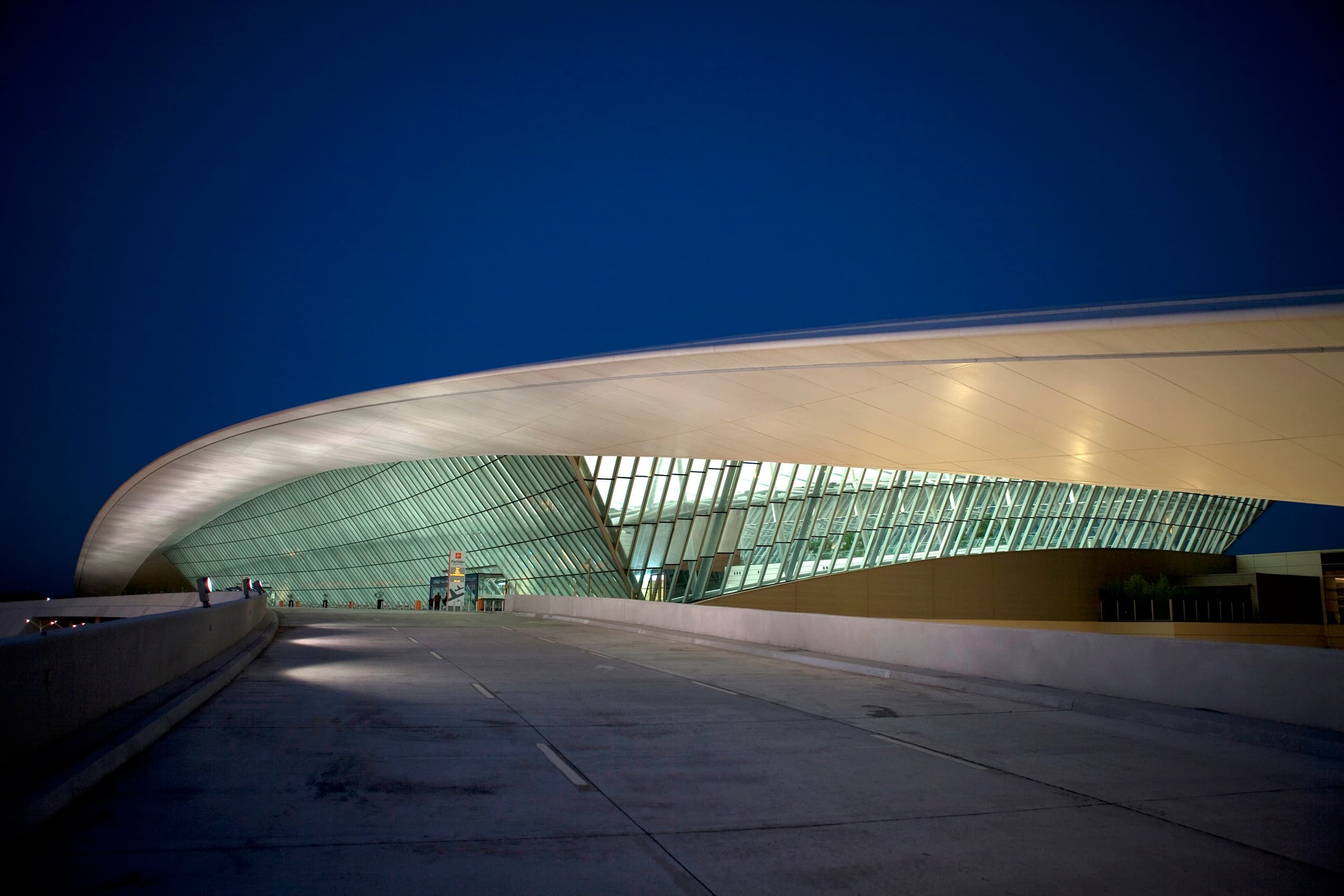 Carrasco International Airport bei Nacht, Montevideo, Uruguay. Beleuchtete, geschwungene Dachkonstruktion.