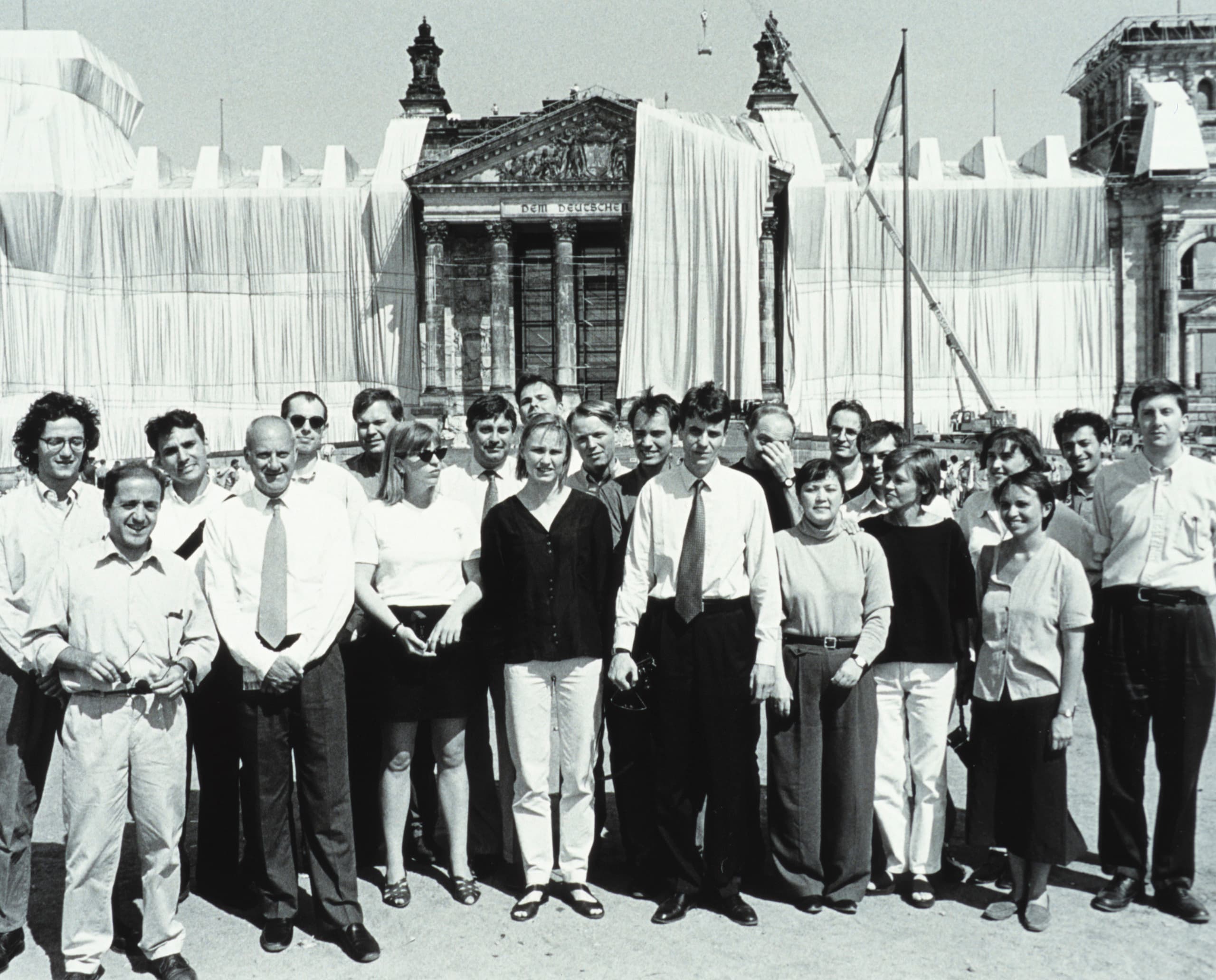 Der verhüllte Reichstag in Berlin mit einer Gruppe von Menschen davor.