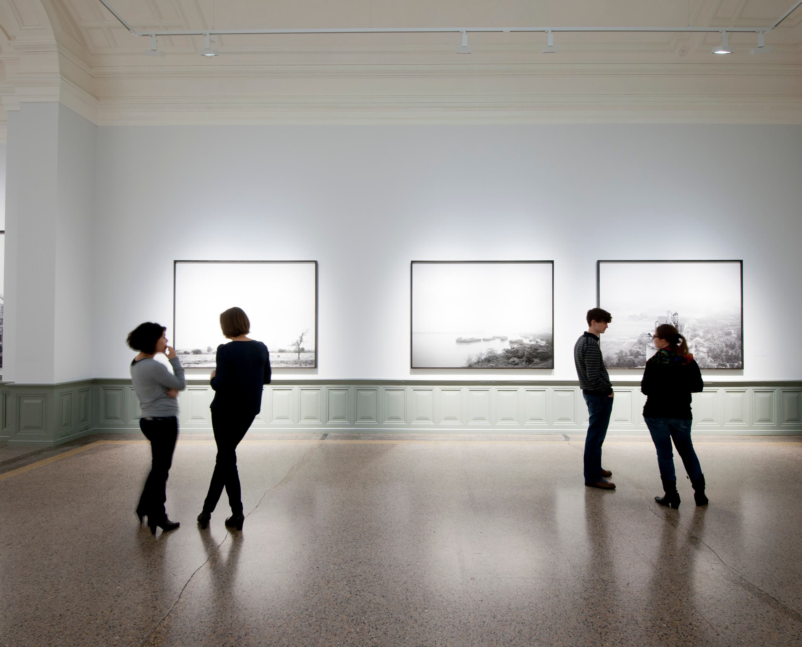 Besucher betrachten Holcim-Fotografien, beleuchtet mit ERCO Light Board LED Strahlern im Kunstmuseum Bern.