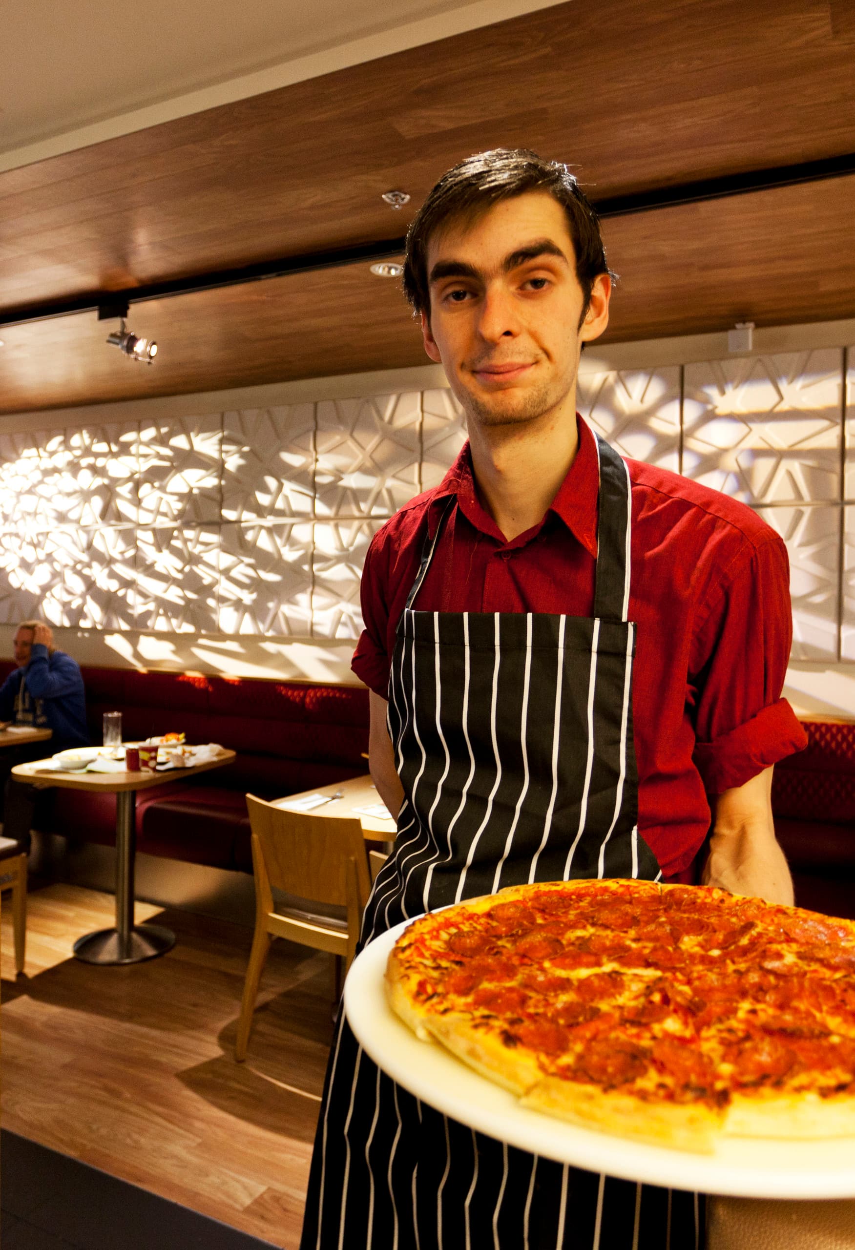 Pizza Hut Restaurant mit ERCO LED-Beleuchtung und Kellner mit Pizza.