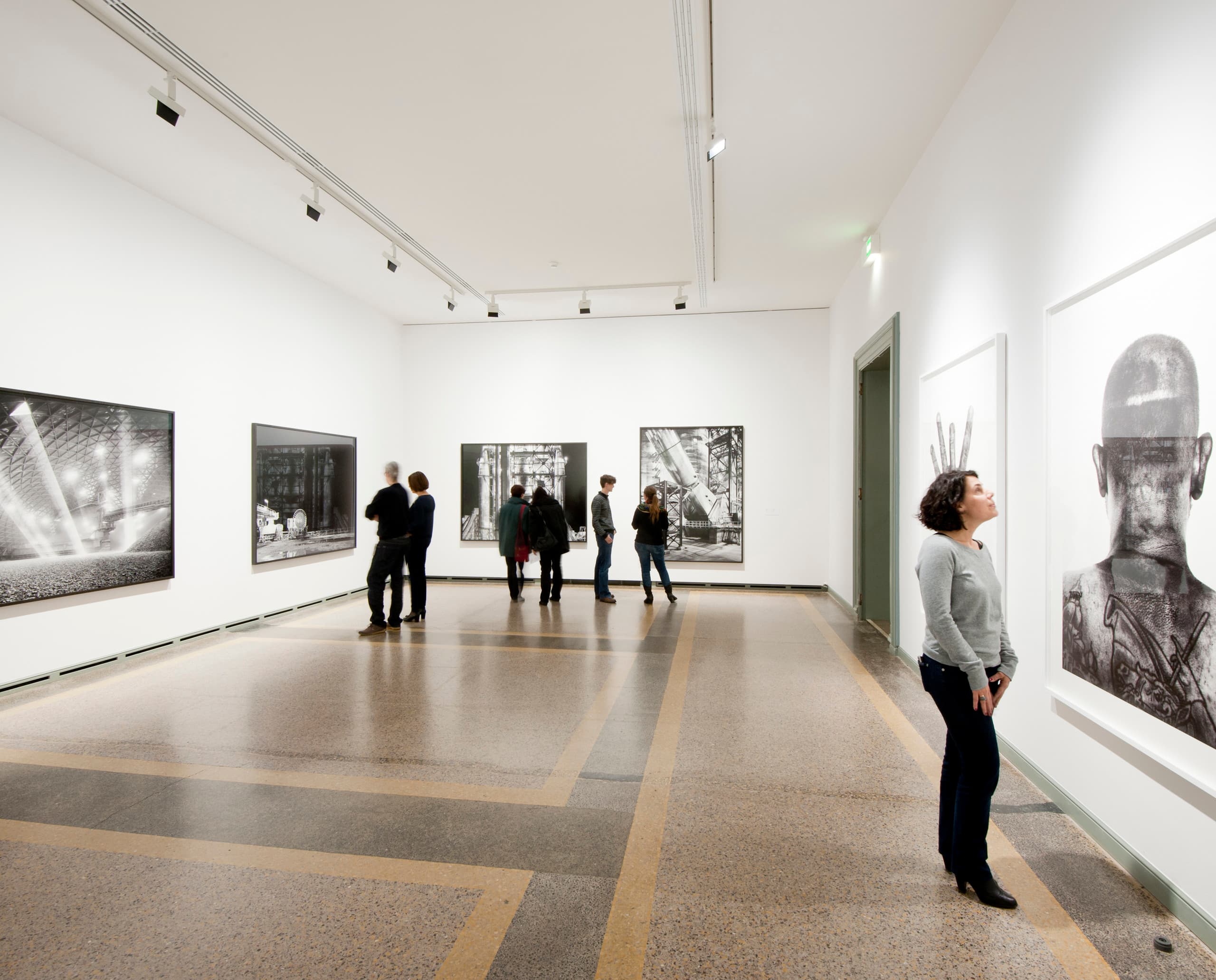 Besucher betrachten die Ausstellung 'Industrious' im Kunstmuseum Bern, beleuchtet mit ERCO Light Board LED Strahlern.
