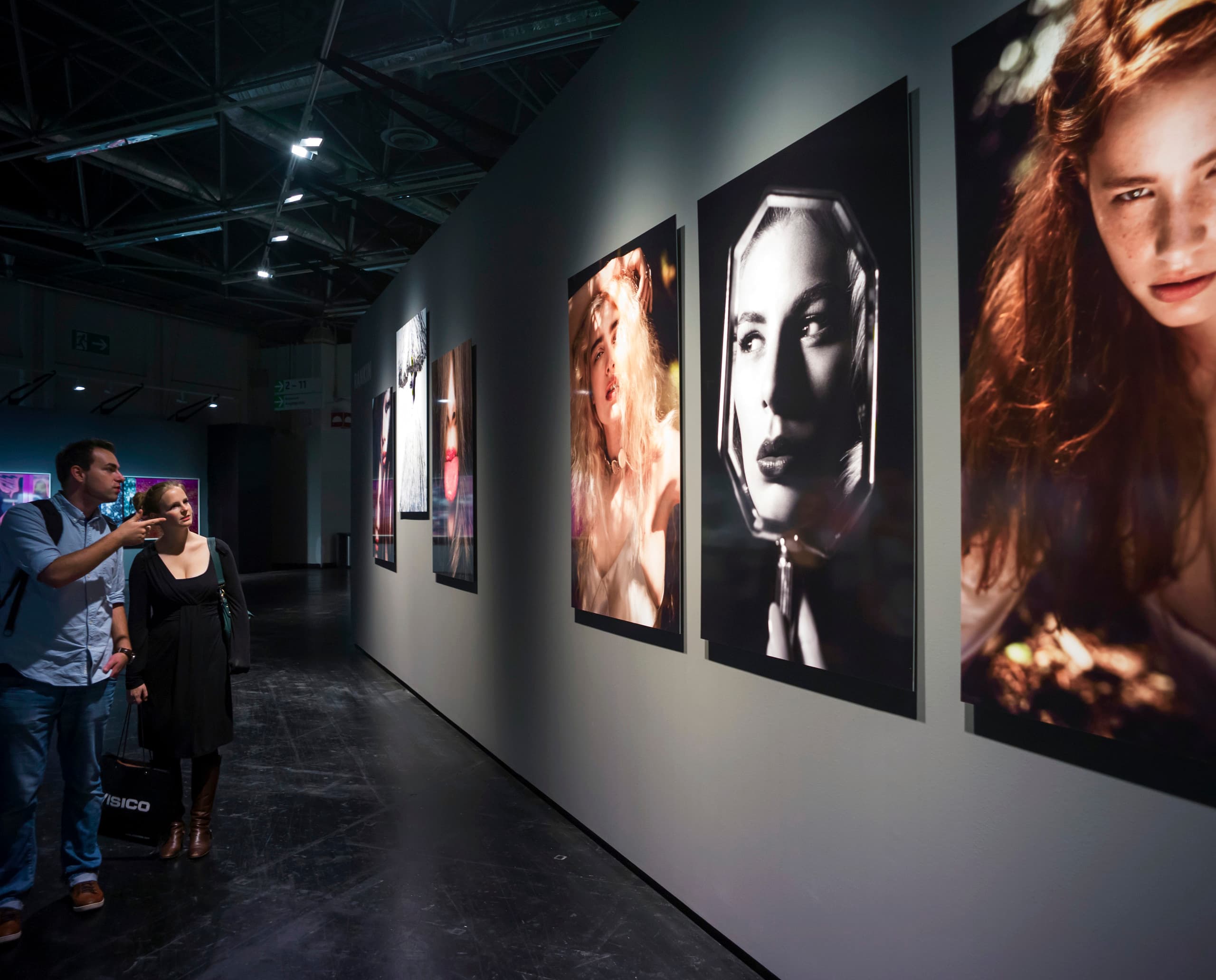 Besucher betrachten Leica-Fotogalerie, beleuchtet mit ERCO Light Board LED-Strahlern auf der Photokina 2012.