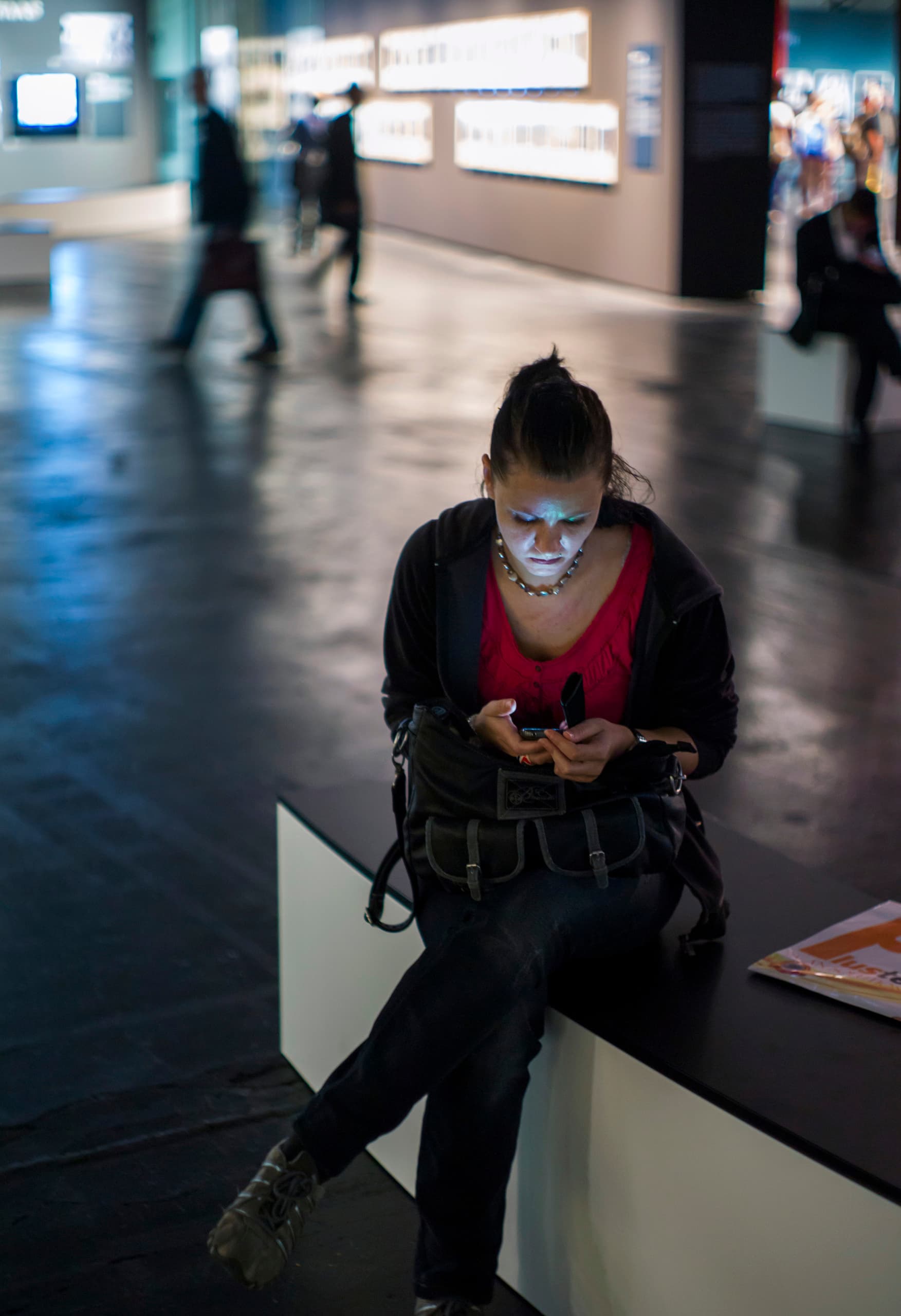 Besucher auf der Photokina 2012 mit ERCO LED-Beleuchtung, die ein Smartphone benutzt.