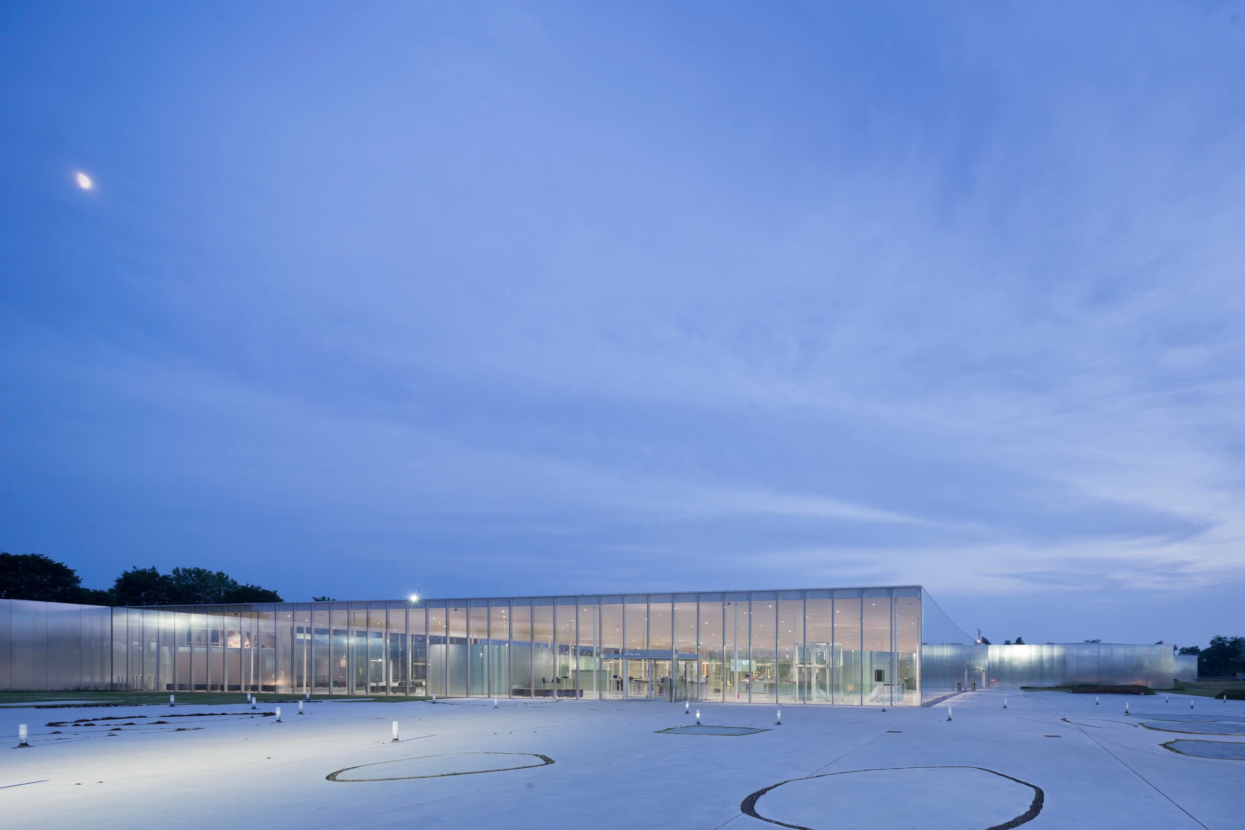 Louvre-Lens Museum bei Dämmerung, beleuchtet mit ERCO LED-Licht für eine transparente und einladende Atmosphäre.