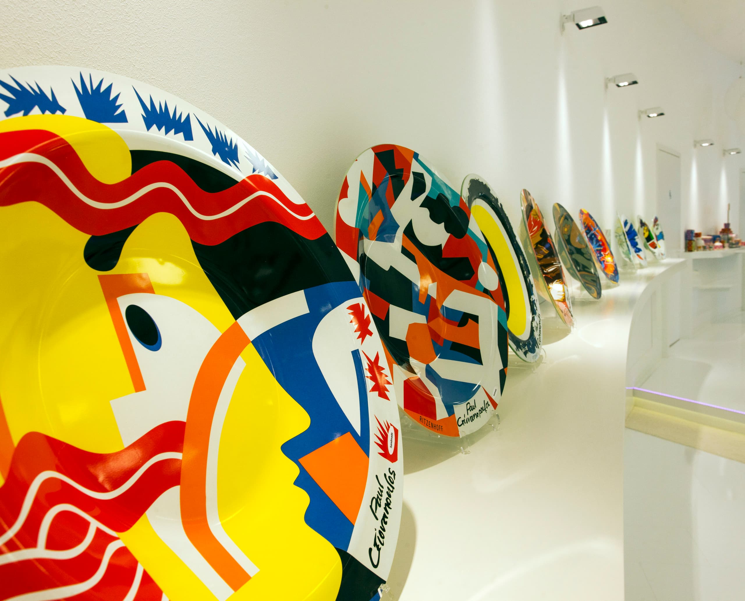 Dekorative Ritzenhoff-Glasplatten im Ausstellungsraum, beleuchtet mit ERCO-Leuchten.