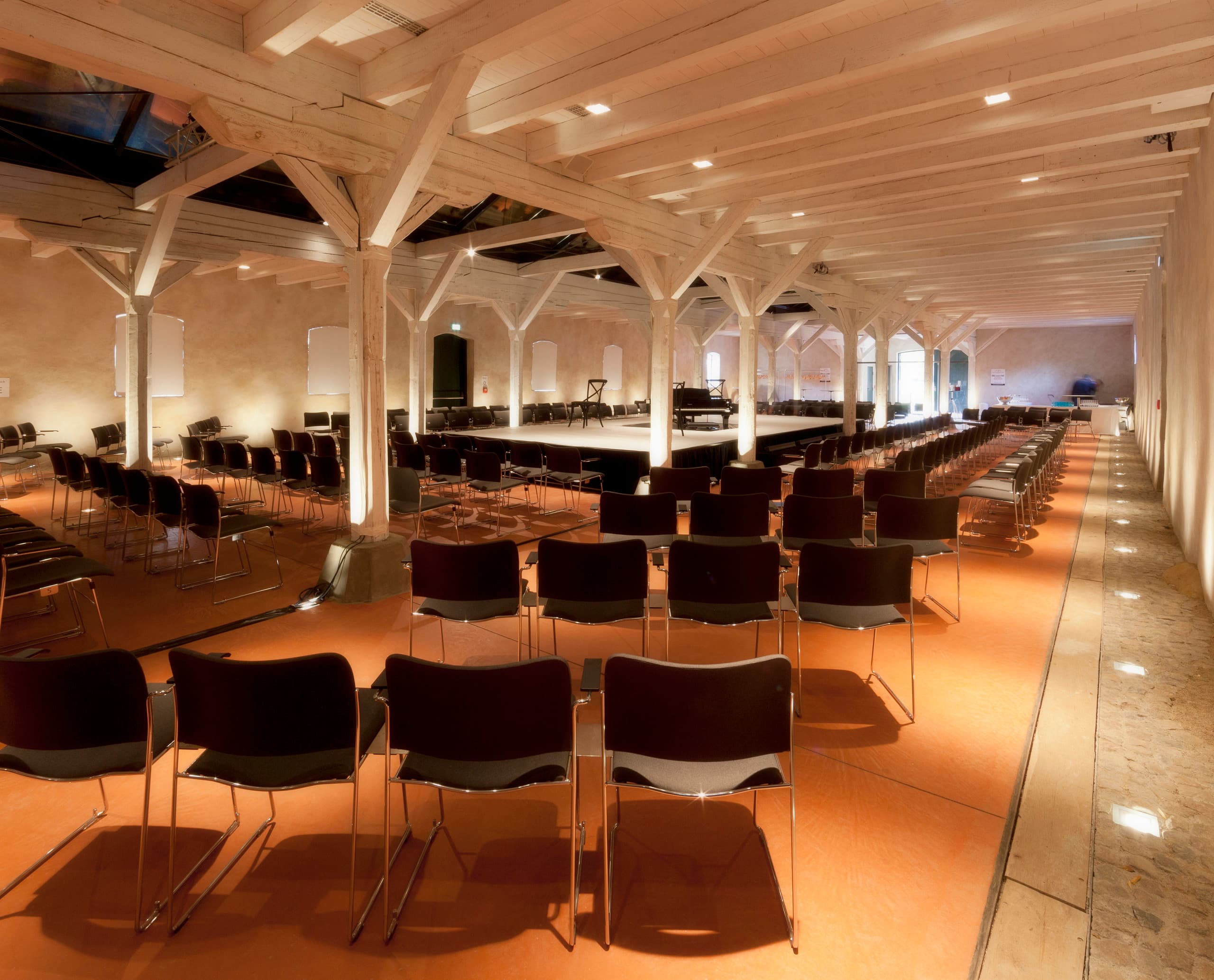Veranstaltungsraum im Hotel Weissenhaus mit ERCO Beleuchtung und Stuhlreihen für Gäste.