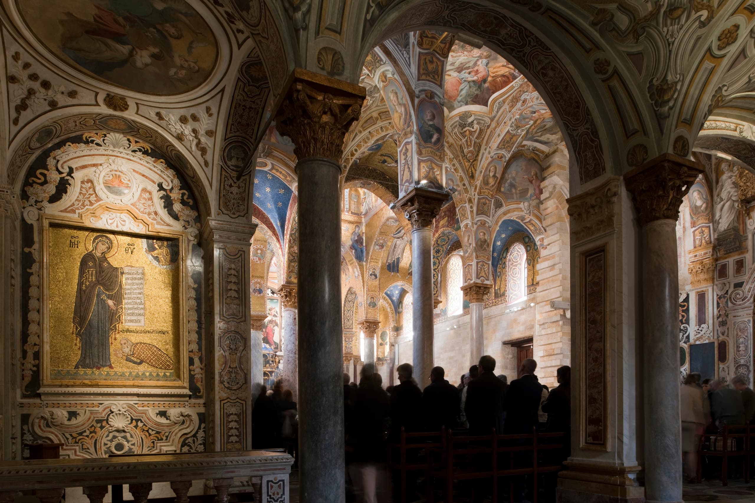 Innenraum der Santa Maria dell’Ammiraglio Kirche in Palermo mit kunstvollen Decken und Besuchern.