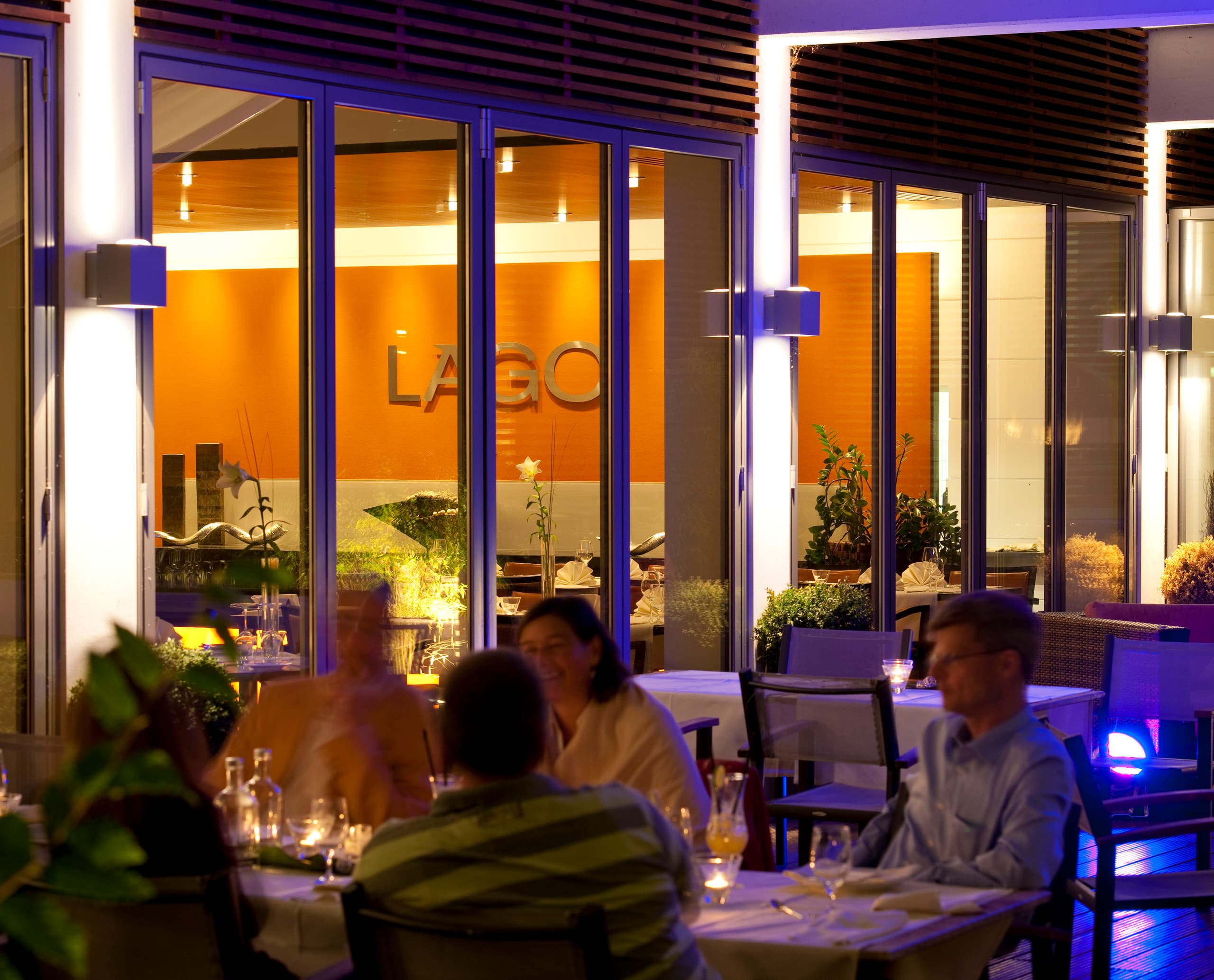 Beleuchtetes LAGO Hotel Restaurant in Ulm mit ERCO Außenleuchten für einladende Atmosphäre.