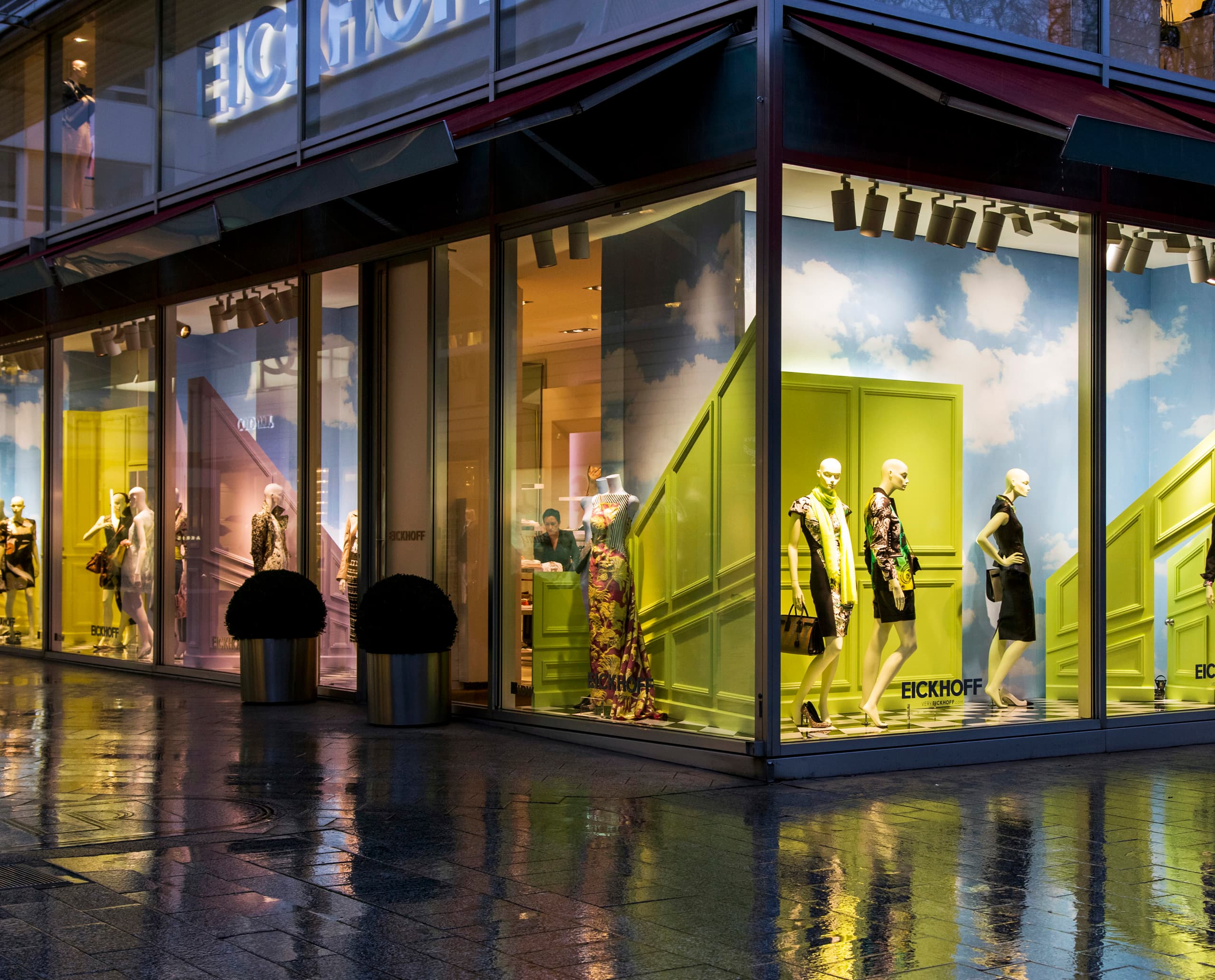 Eickhoff Modehaus Düsseldorf Schaufenster mit LED-beleuchteten Mannequins und surrealem Bühnenbild.