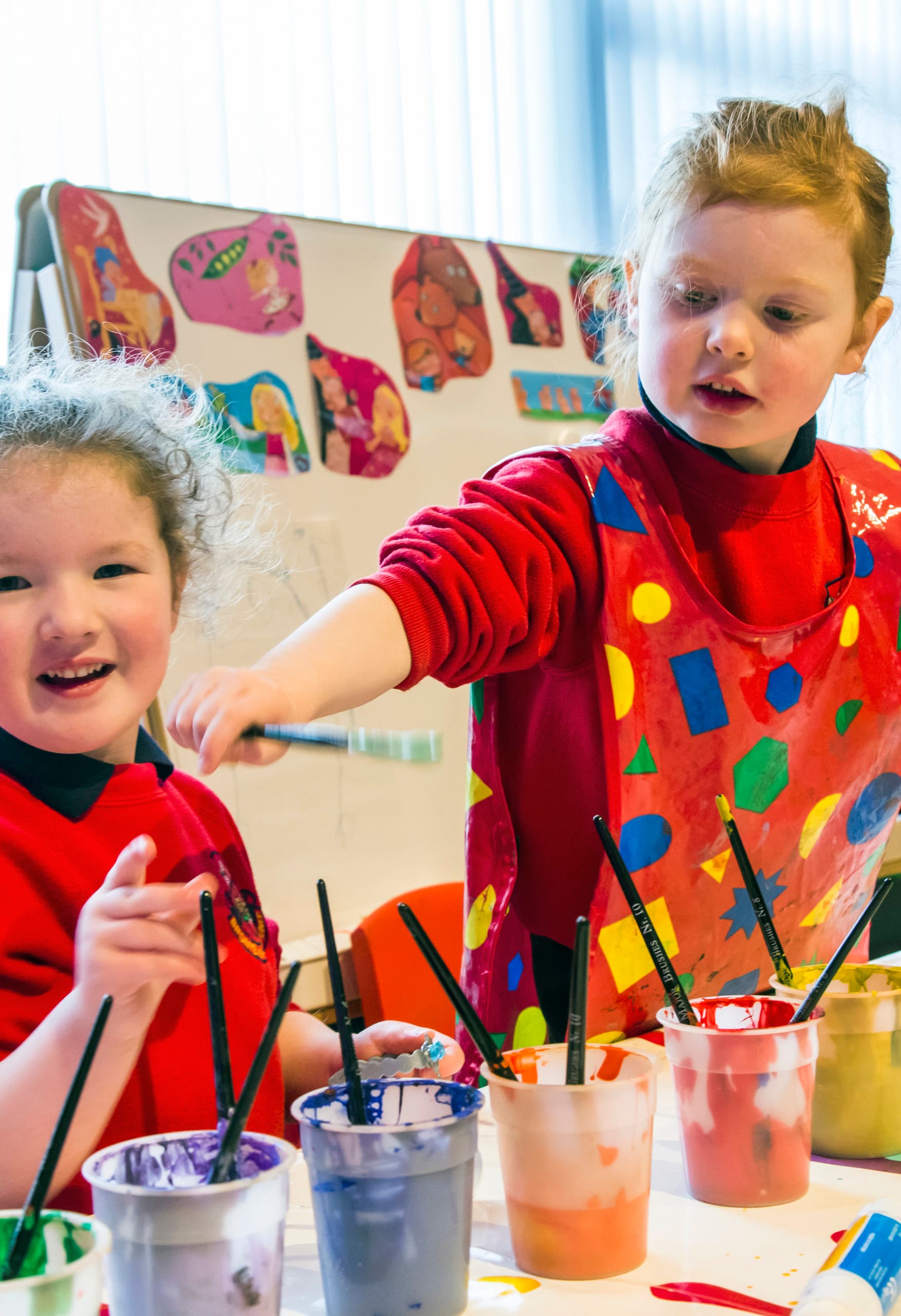 Kinder malen mit Pinseln im Brontë Kindergarten, Rathfriland.
