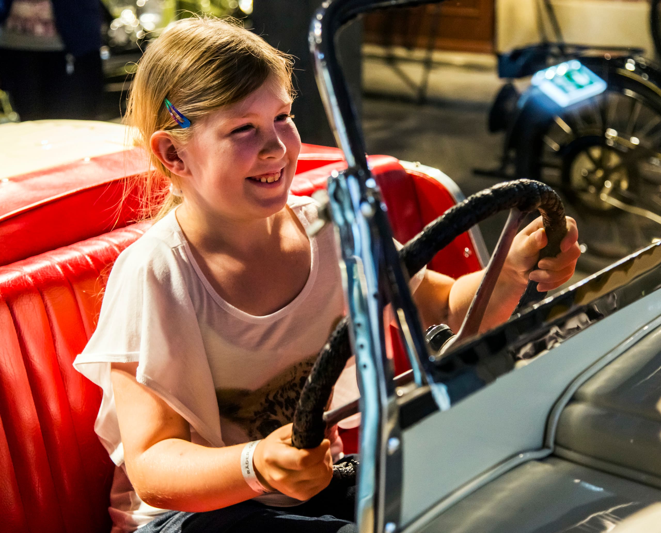 Mädchen am Steuer eines Oldtimers im PS.Speicher Museum, Einbeck.
