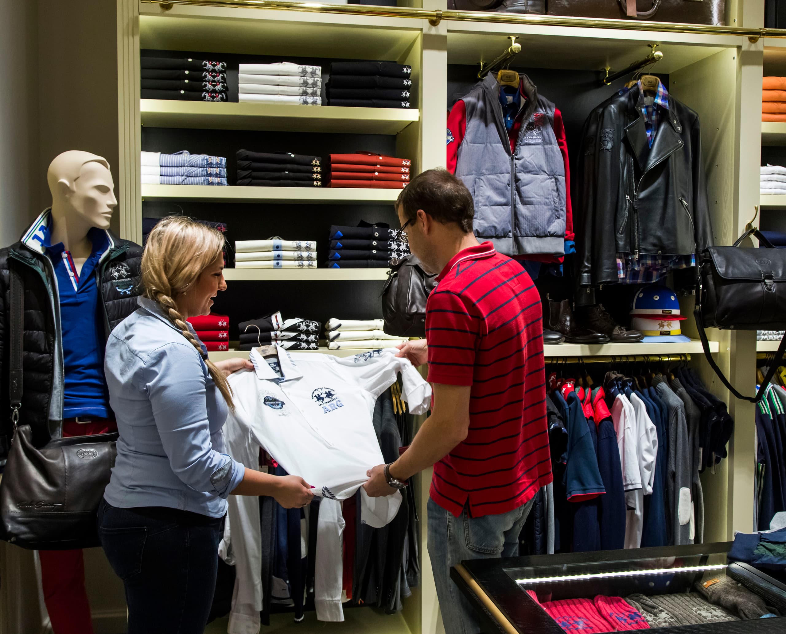 Kunden wählen La Martina Poloshirt in Boutique mit ERCO LED-Beleuchtung.