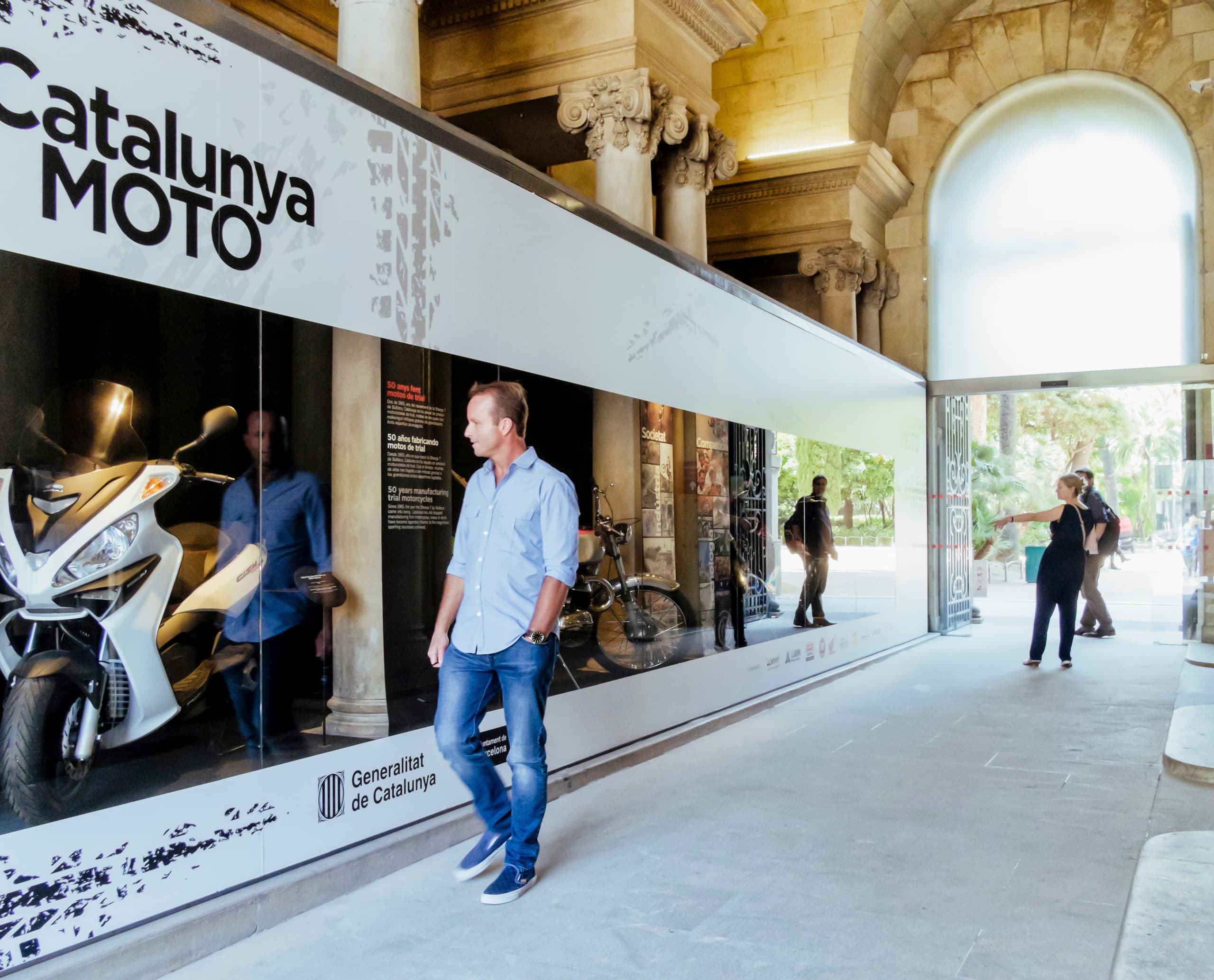 Besucher betrachtet Motorrad-Ausstellung im Palau Robert, beleuchtet mit ERCO Strahlern.
