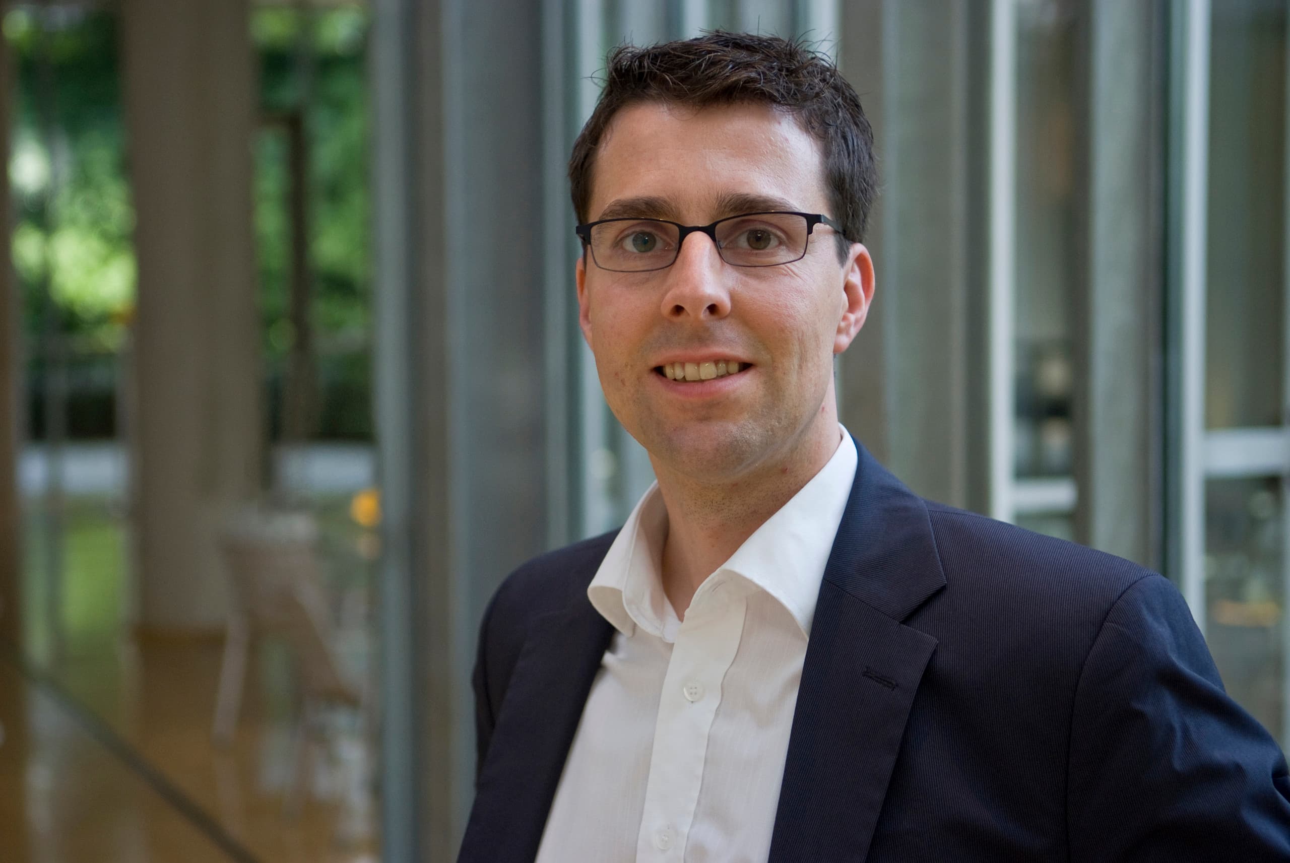 Porträt eines Mannes mit Brille, der im Bereich Lichtplanung und Retail-Design tätig ist.