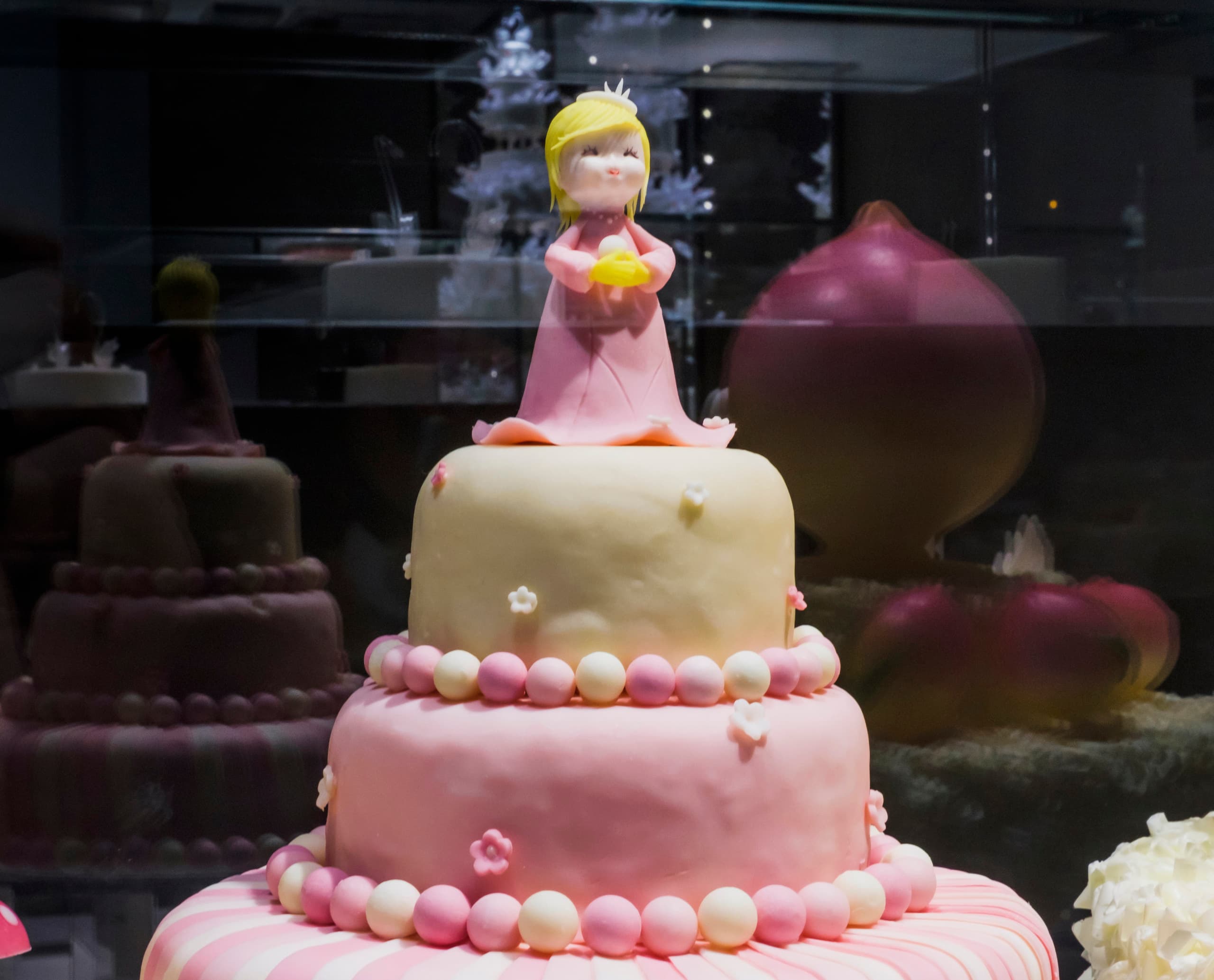 Dekorierte Torte mit Prinzessin-Figur in der Black Swan Patisserie, beleuchtet mit ERCO Optec Strahlern.