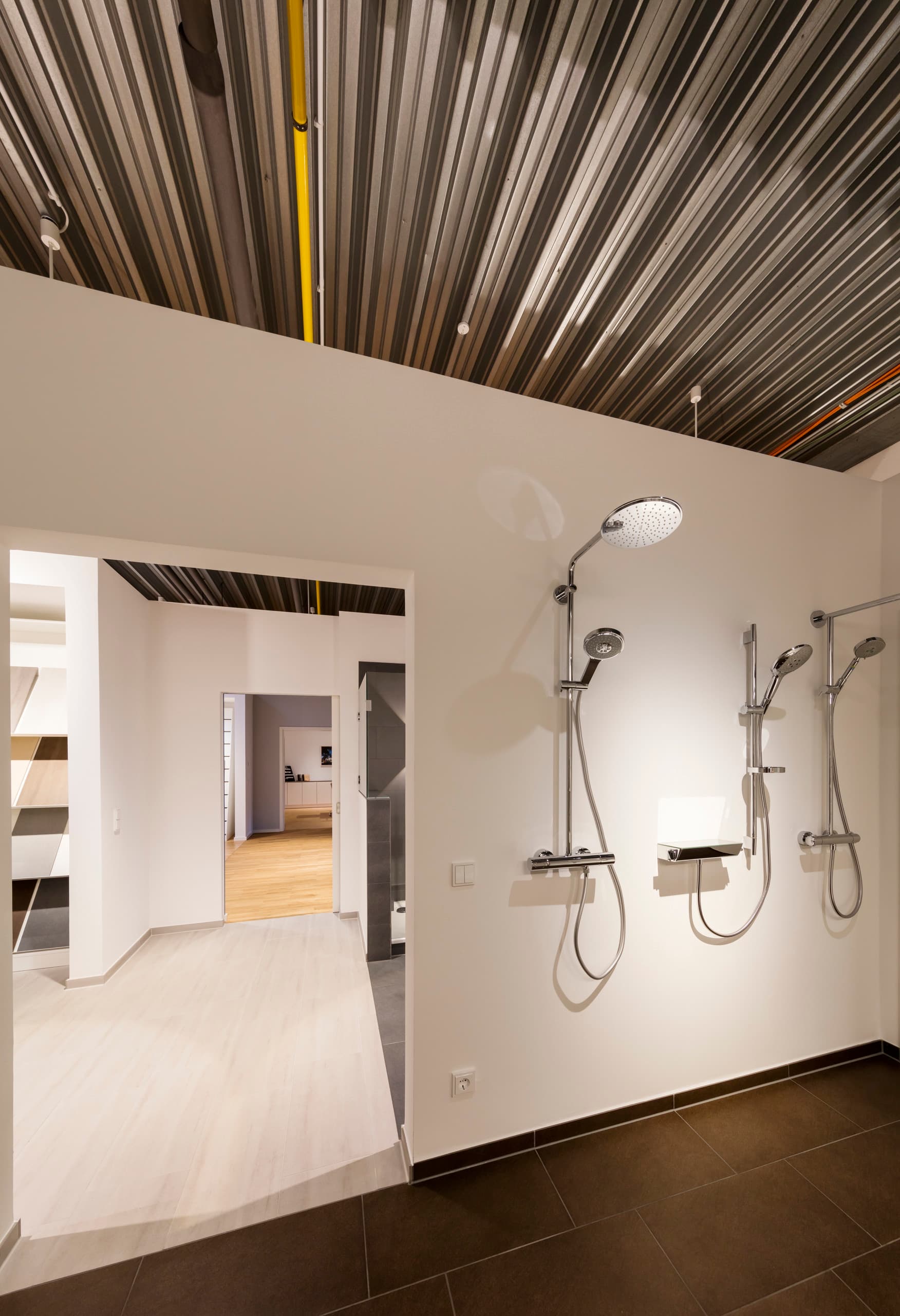 Duscharmaturen im Otto Wulff Showroom, präsentiert mit ERCO LED-Beleuchtung für hochwertige Materialauswahl.