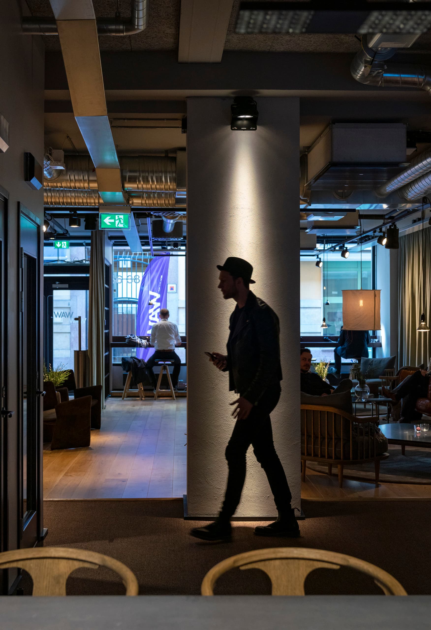 ERCO LED-Spot beleuchtet einen Mann in einem modernen Büro, Teil des Projekts "Work away from Work".