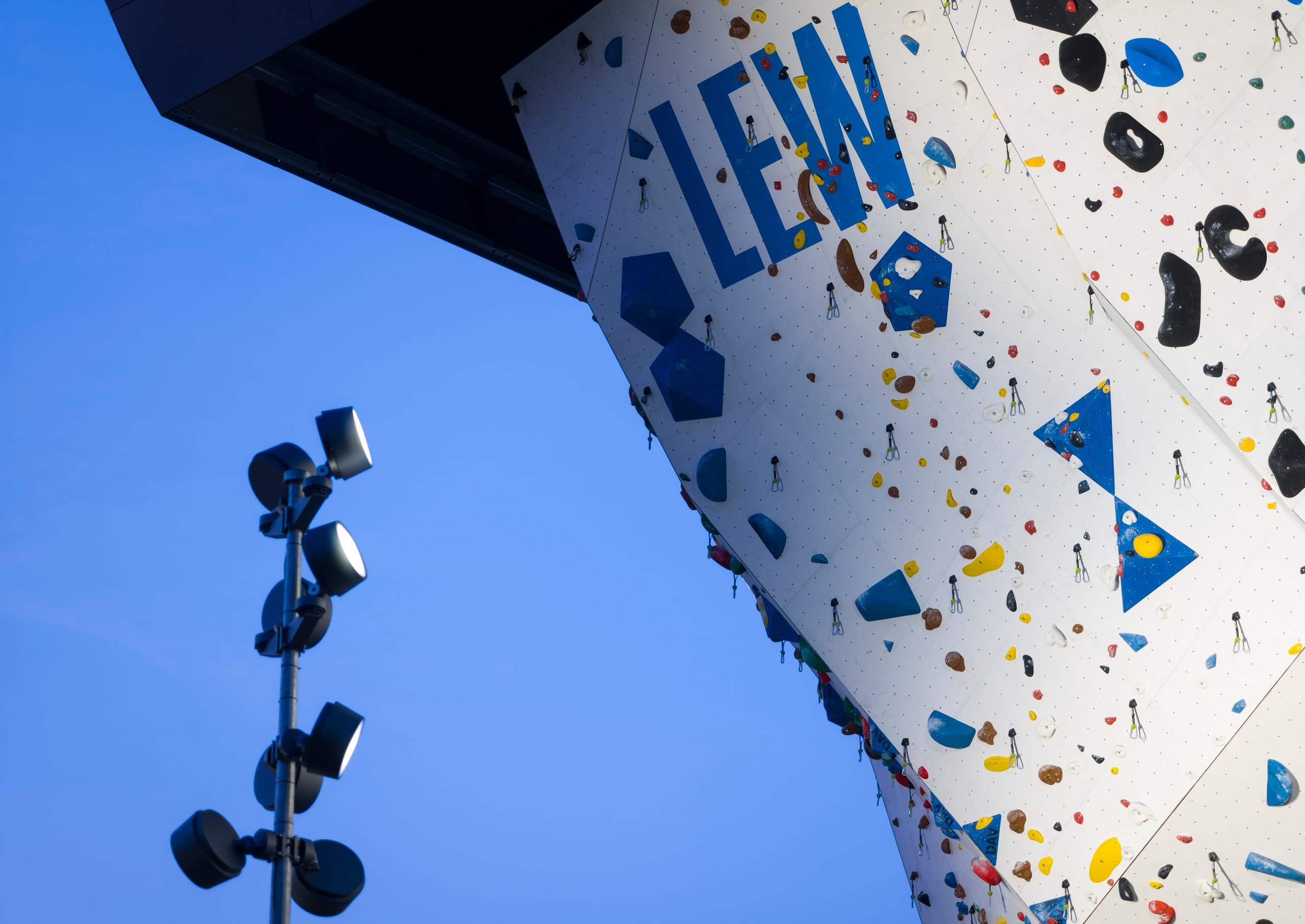 Beleuchteter Kletterturm mit LED-Strahlern, die die Griffe hervorheben und für Sicherheit sorgen.