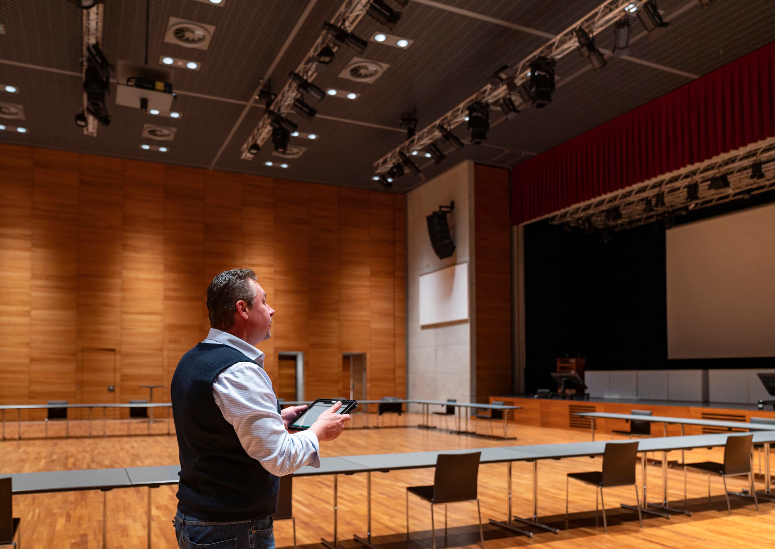 Mann mit Tablet im Ferry Porsche Congress Center, Zell am See. ERCO LED-Beleuchtung für Energieeffizienz.