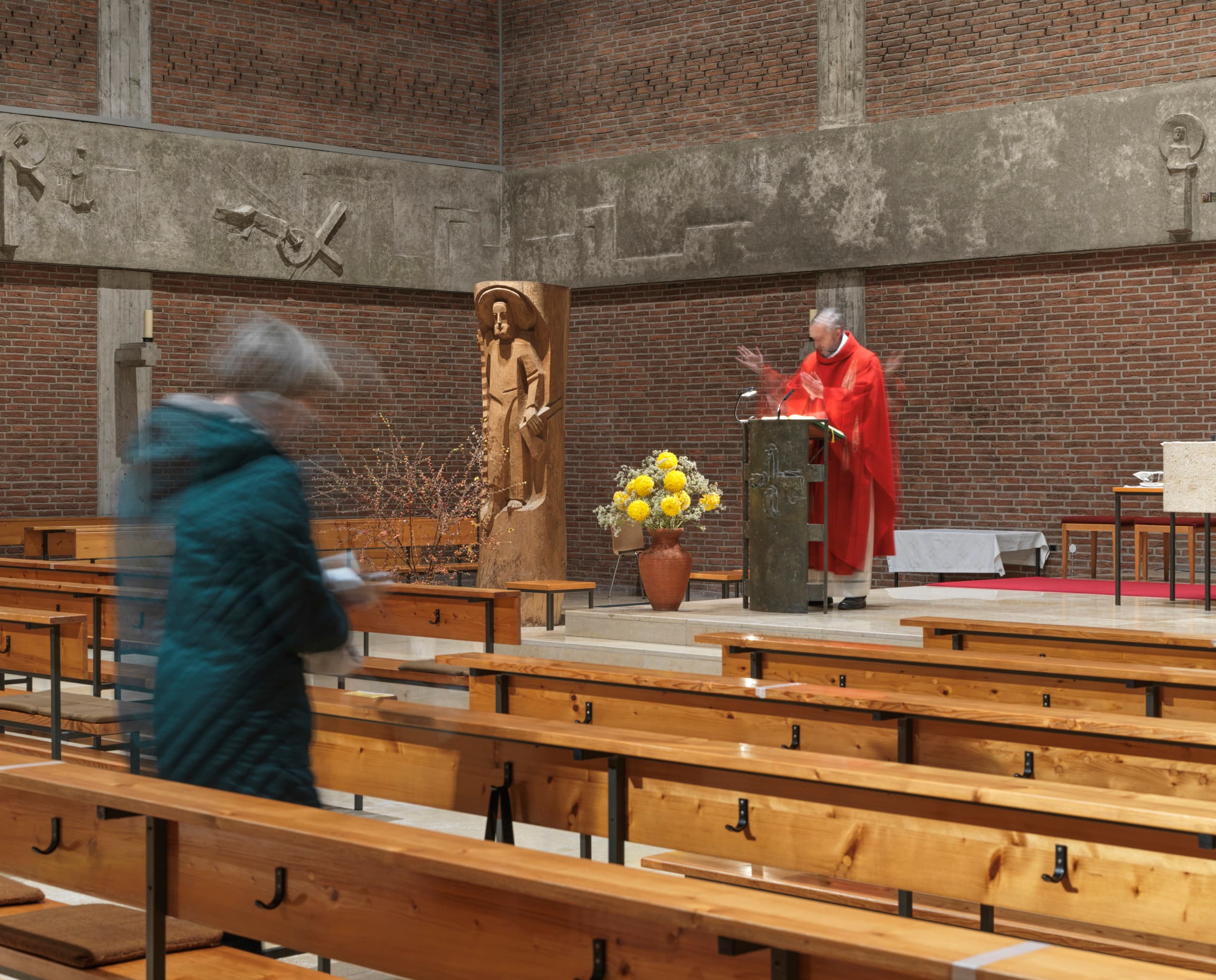 Pfarrer in der St. Joseph Kirche, Karlsfeld, beleuchtet mit ERCO Atrium Pendelleuchten und Parscan Strahlern.