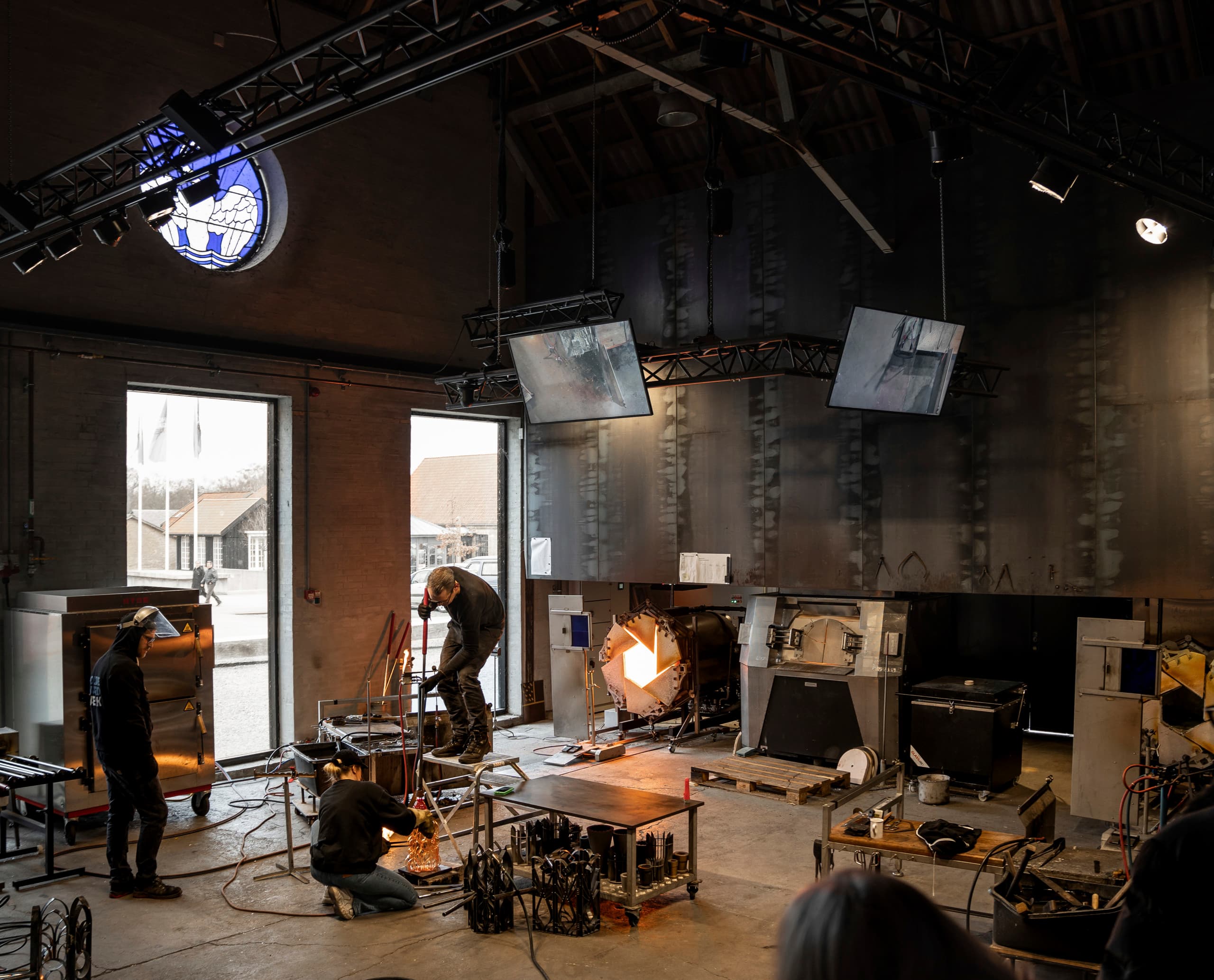 Glasbläser bei der Arbeit im Holmegaard Værk Museum, beleuchtet mit ERCO LED-Strahlern.