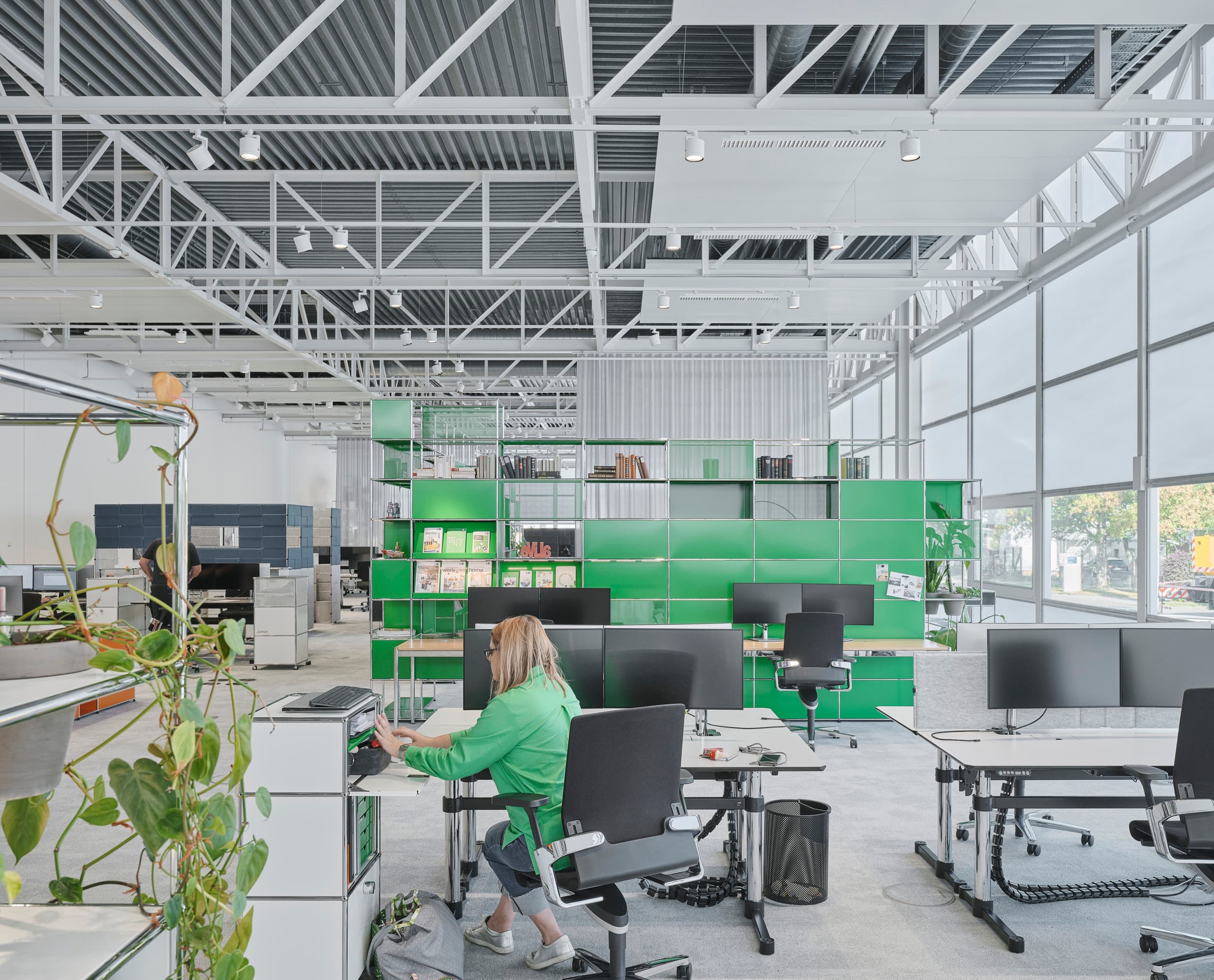 Flexibles ERCO-Lichtdesign im USM Show Office mit Jilly Downlights und Parscan Strahlern für anpassbare Bürobeleuchtung.