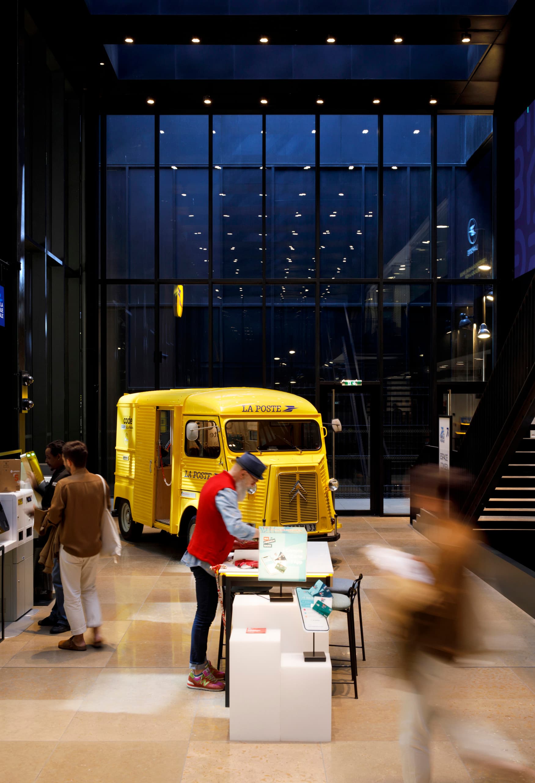 ERCO LED-Strahler beleuchten den gelben Oldtimer-Postwagen im Louvre Post Office, Paris.