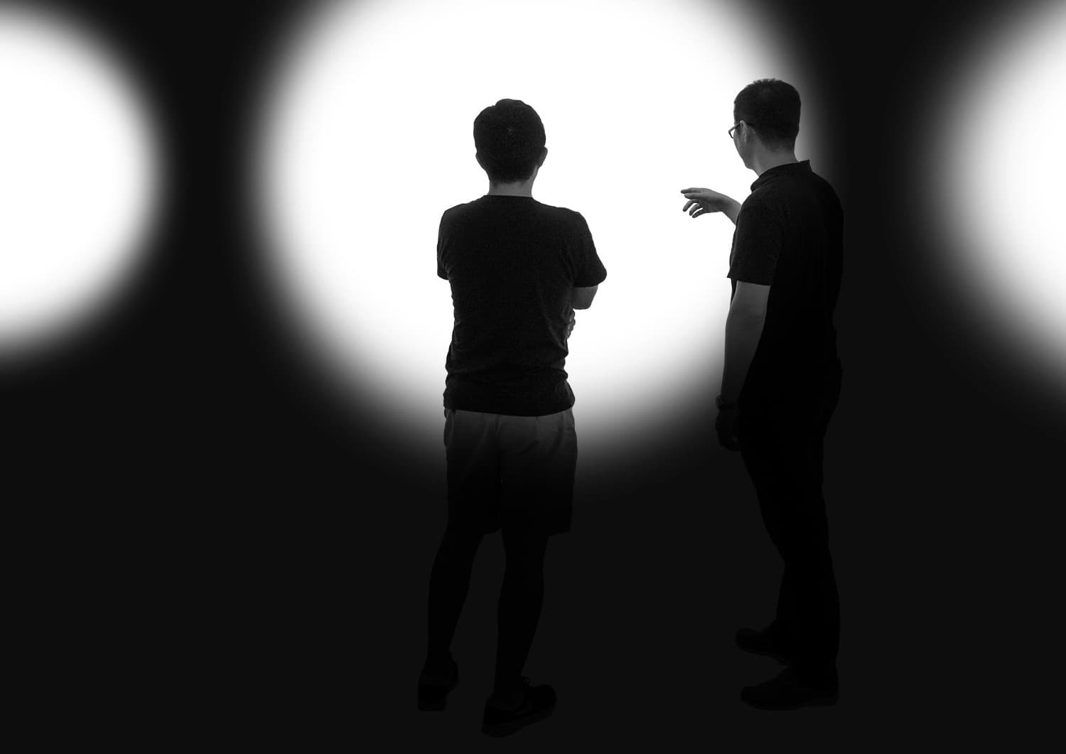 Zwei Personen im Gespräch unter Baumbeleuchtung, die Lichtverteilung und Design besprechen.