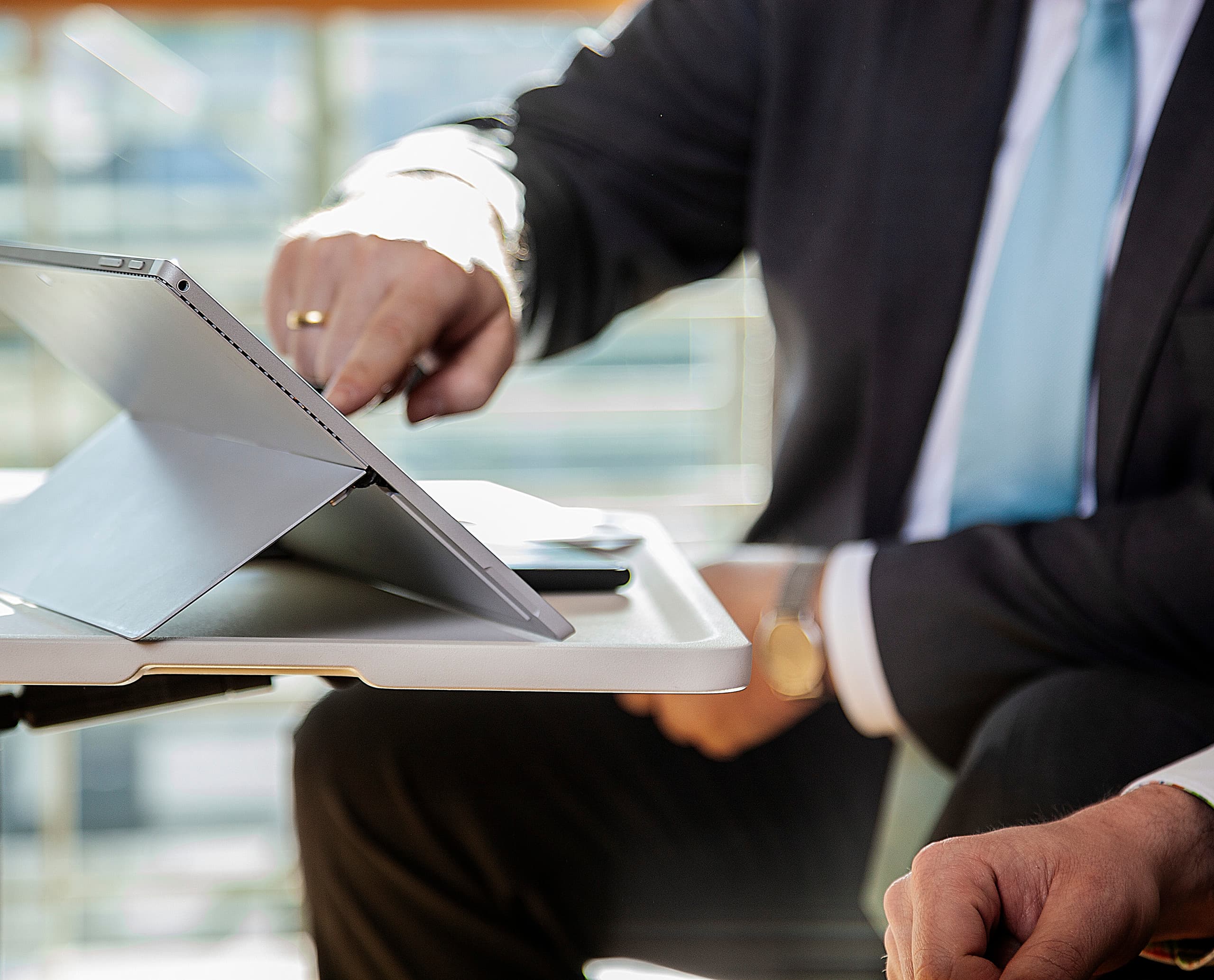 Ein Mann arbeitet an einem Tablet. Fokus auf effiziente Zusammenarbeit und digitale Prozesse.