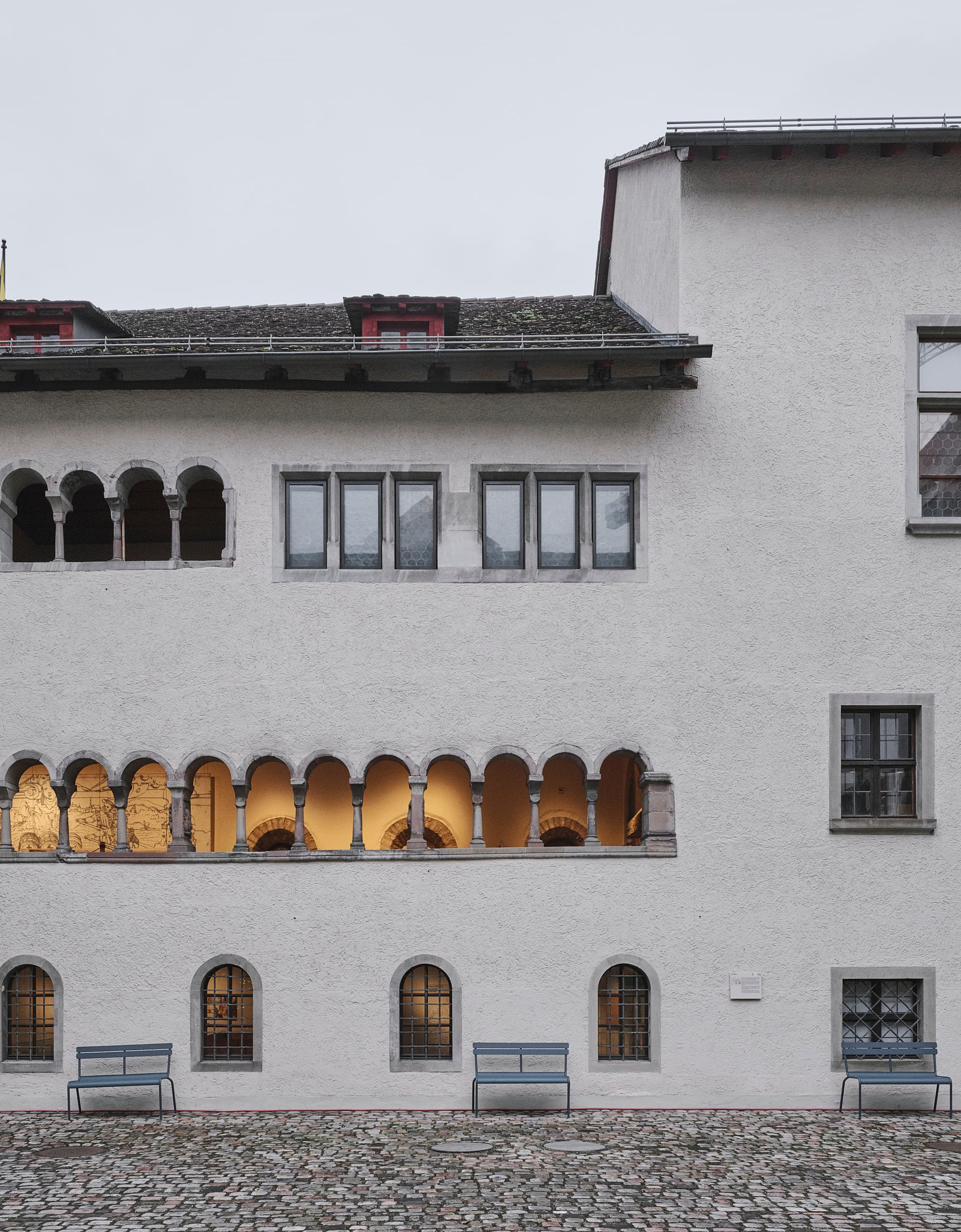 Außenansicht mit kleinen, Licht durchfluteten Fenstern eines Museums.