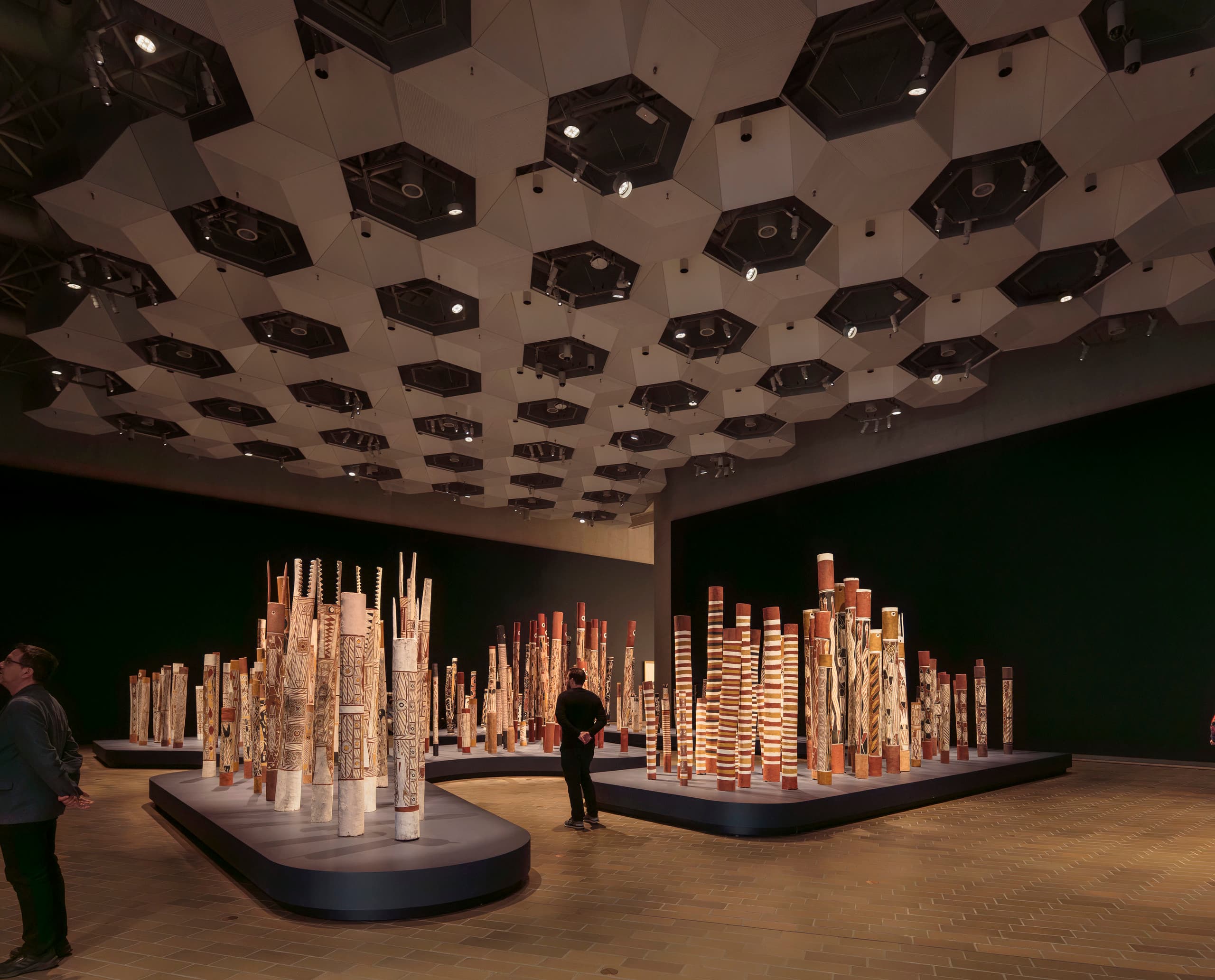 Dunkler Ausstellungsraum mit Skulpturen und löchriger Decke.