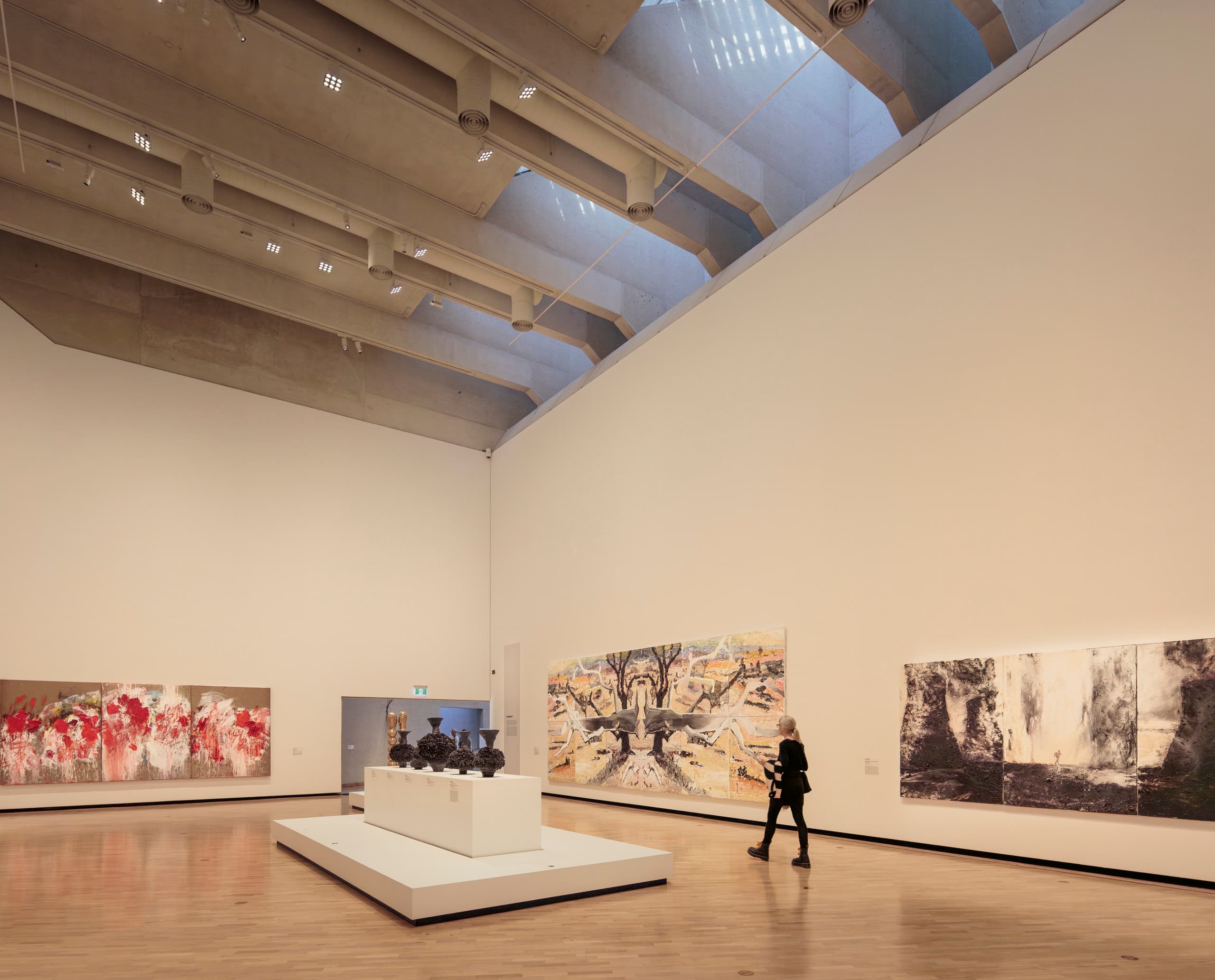 Ausstellungsraum mit Gemälden, hohen Wände und hoher Decke.