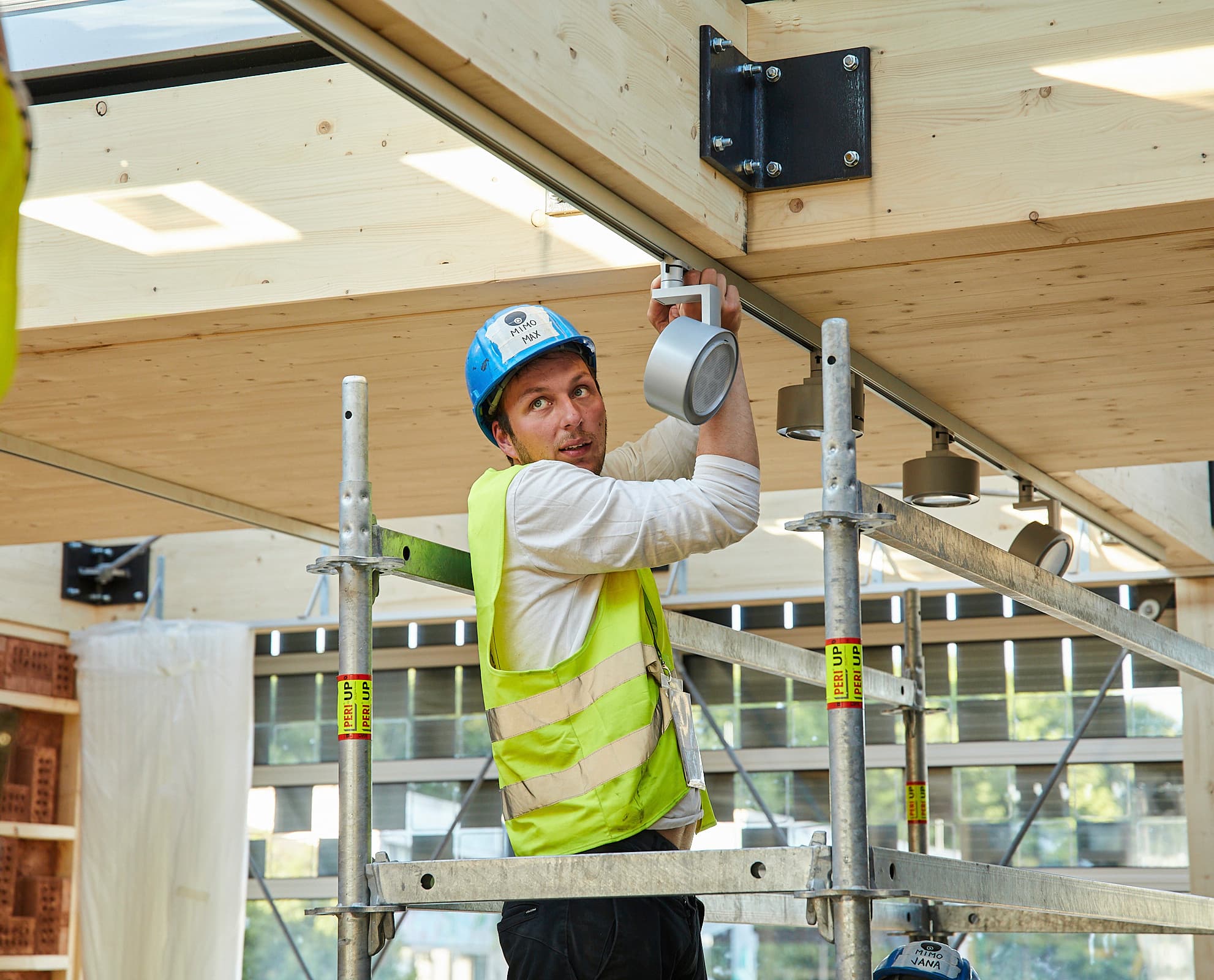 Elektriker installiert ERCO Strahler in nachhaltigem Gebäude des Solar Decathlon Europe 21/22.