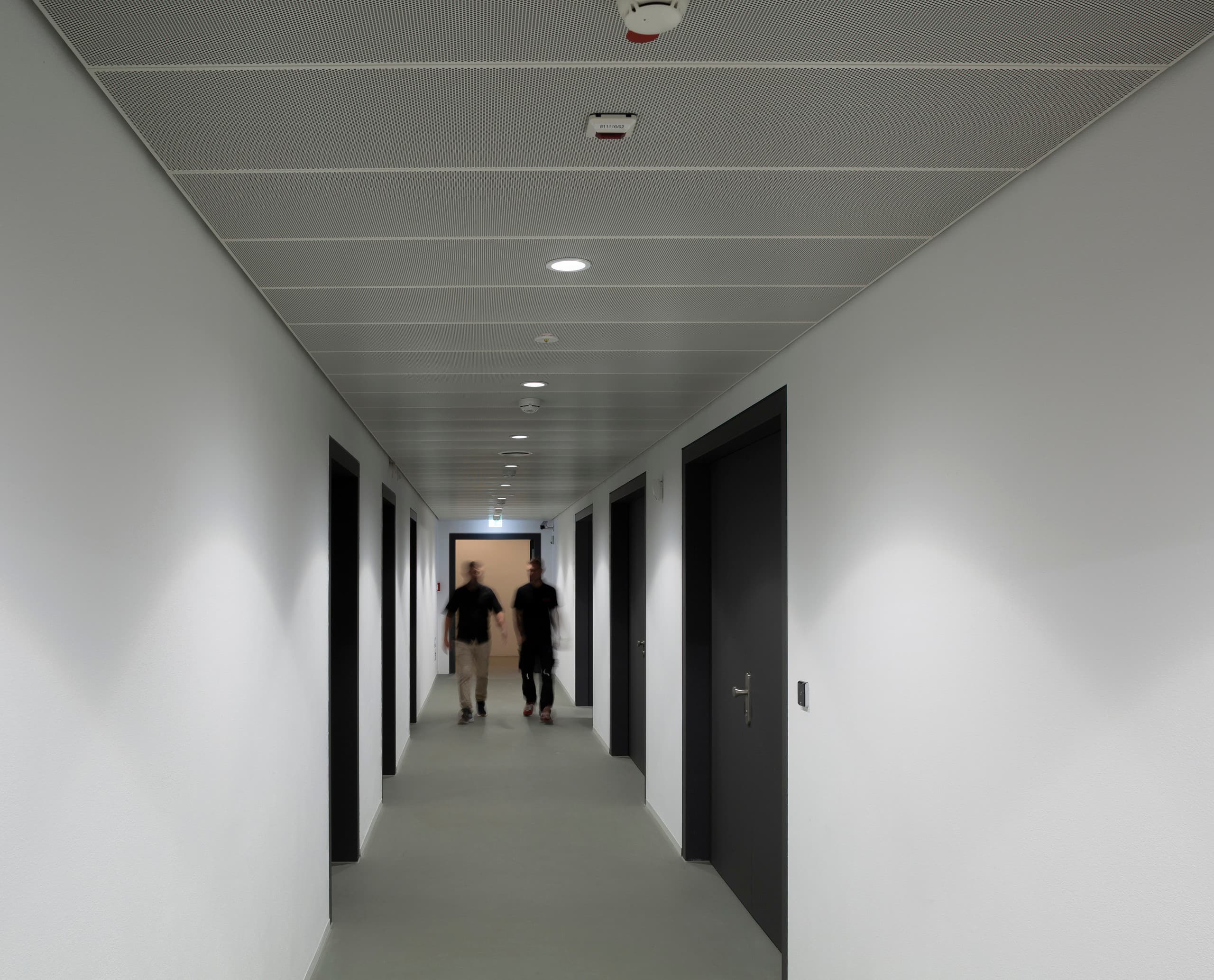 Flur im Blockhaus Dresden mit ERCO Skim Downlights für gleichmäßige Ausleuchtung.