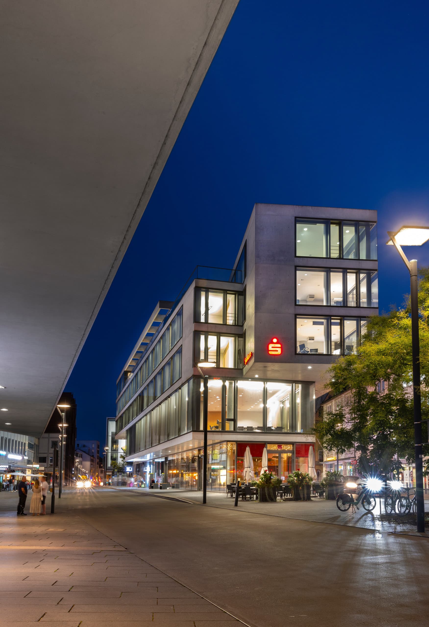 Sparkasse Ulm bei Nacht, beleuchtet mit ERCO LED-Downlights für verbesserte Energieeffizienz und Lichtqualität.