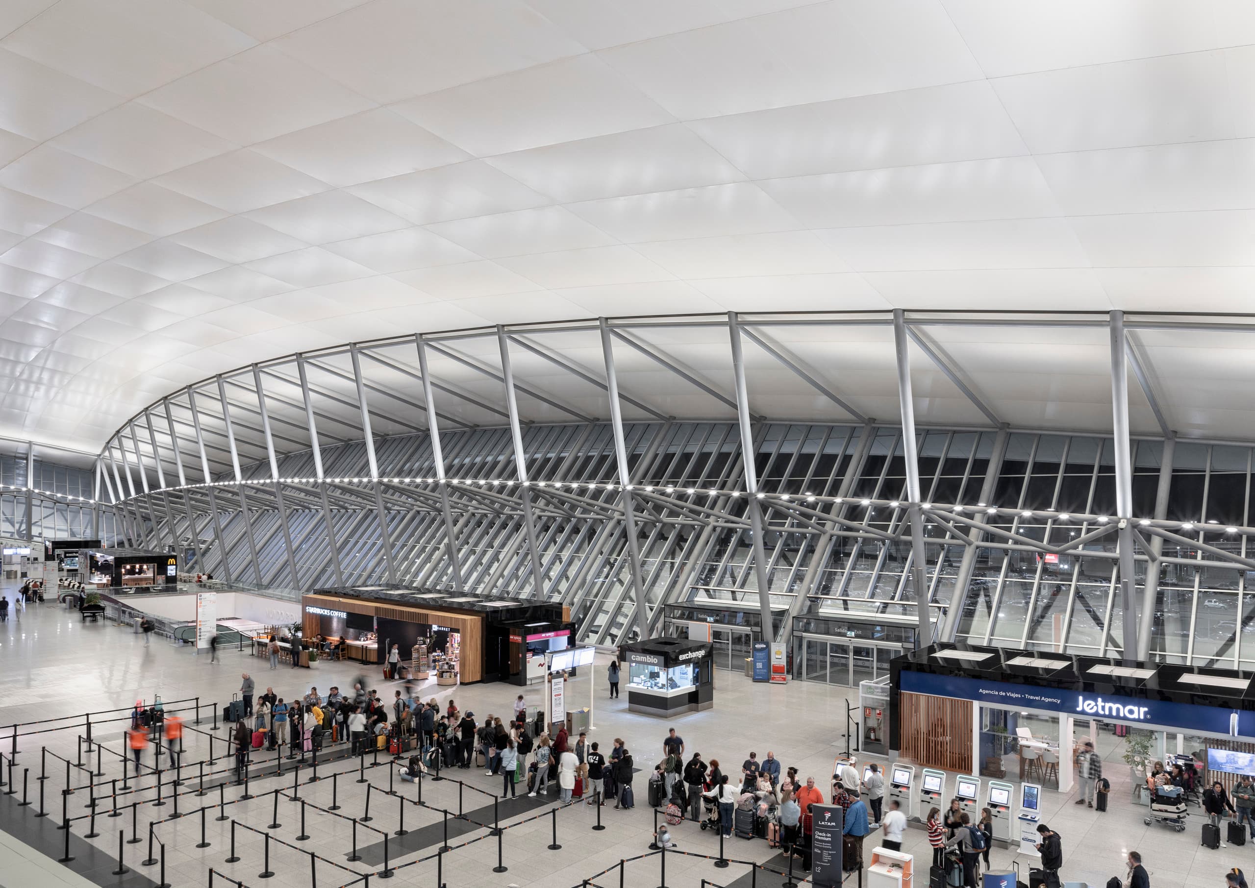 Innenansicht des Carrasco International Airport mit LED-Beleuchtung und wartenden Reisenden.