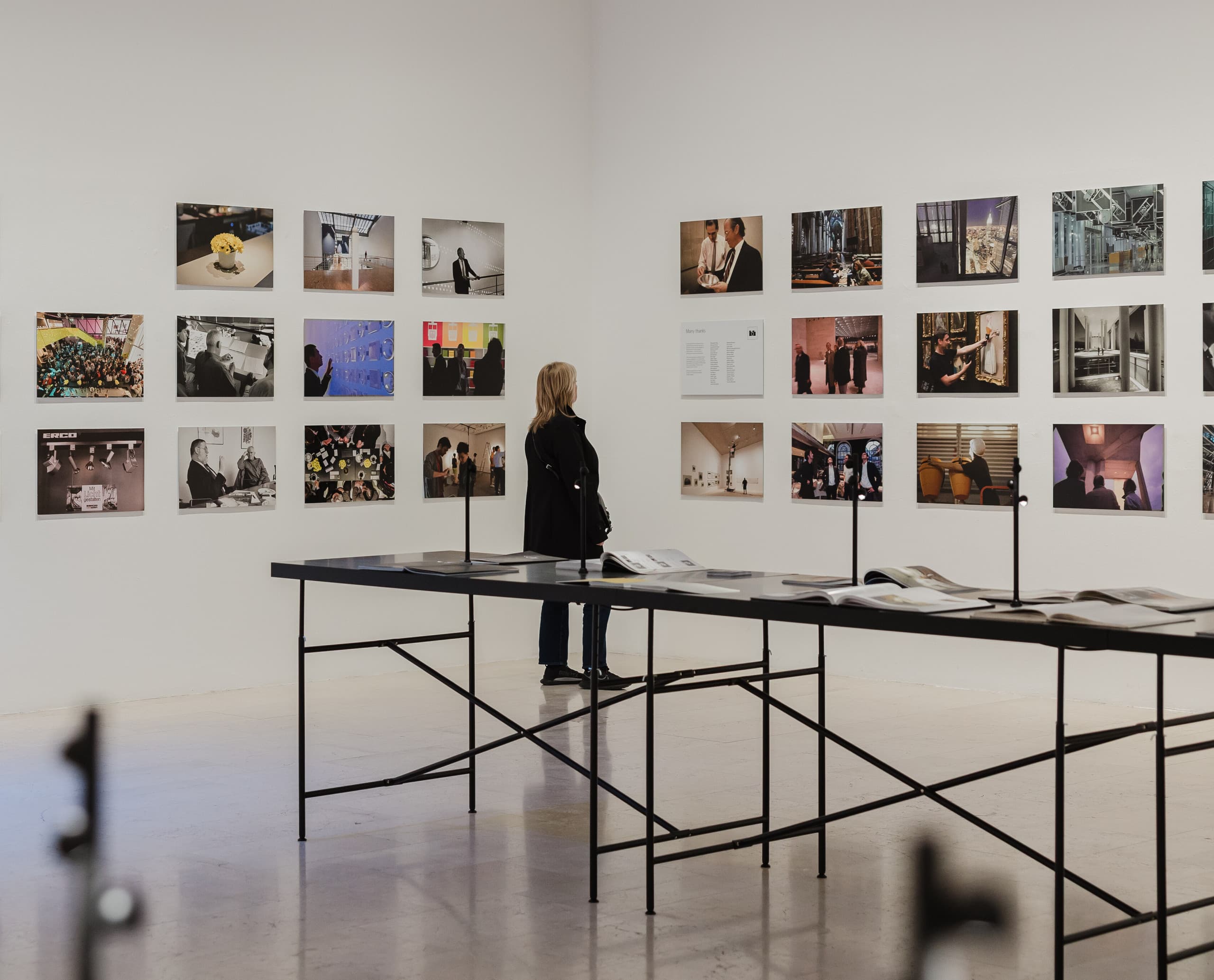 Besucher betrachtet die ERCO Light Box Ausstellung in Mailand, die Licht und Architektur durch Fotografie zeigt.