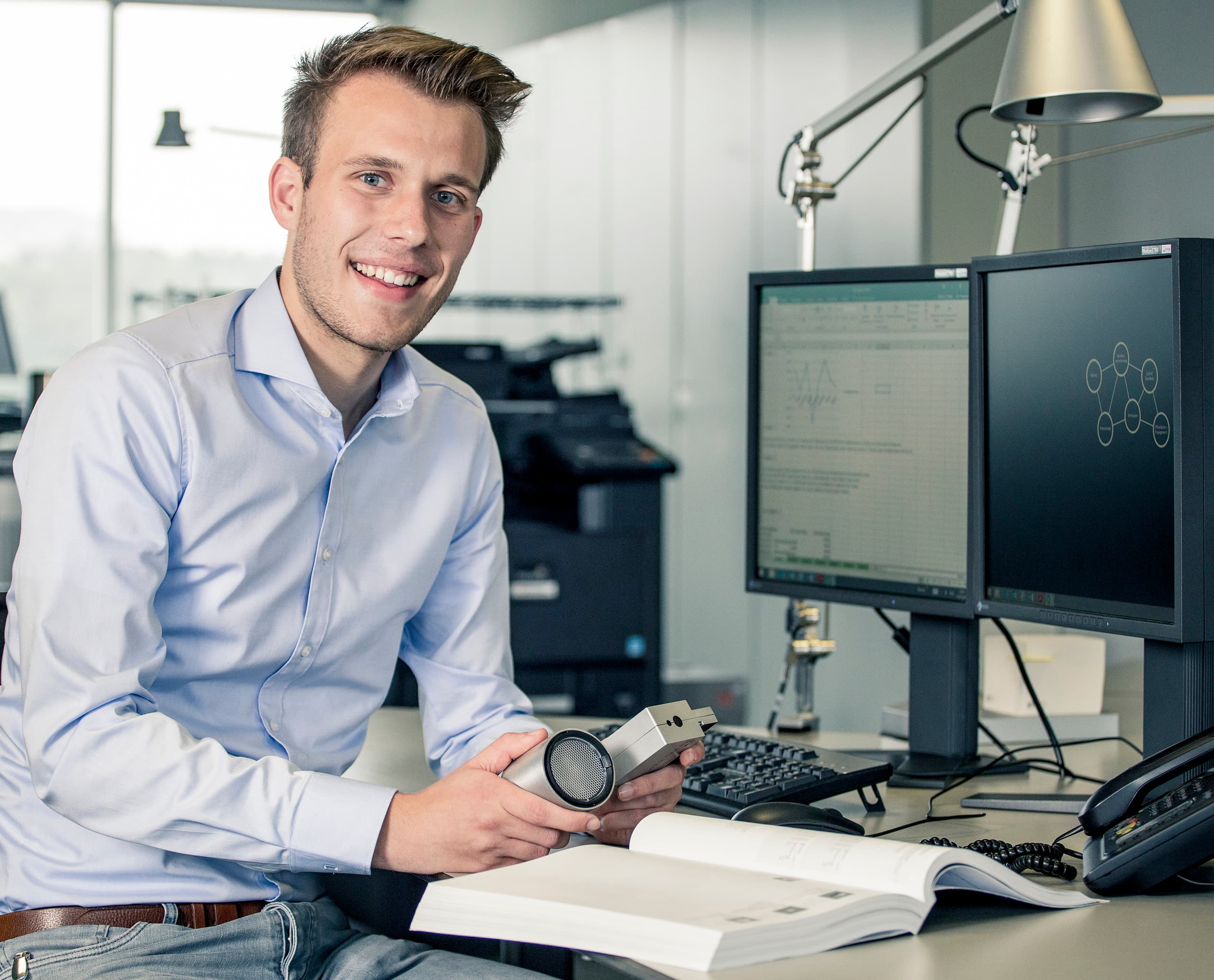 ERCO Auszubildender bei der Arbeit mit einem Lichtprodukt im Büro.